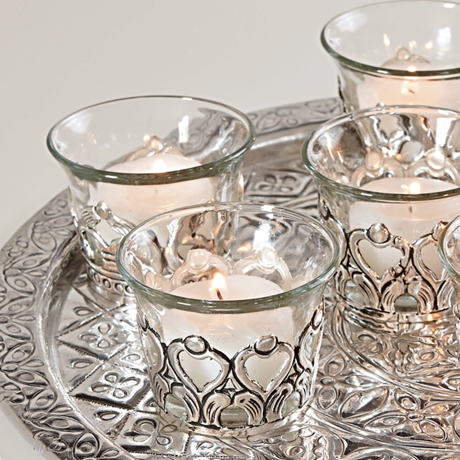 Glas-Teelichthalter mit silbernen Metallverzierungen auf dekorativem Tablett für Zuhause