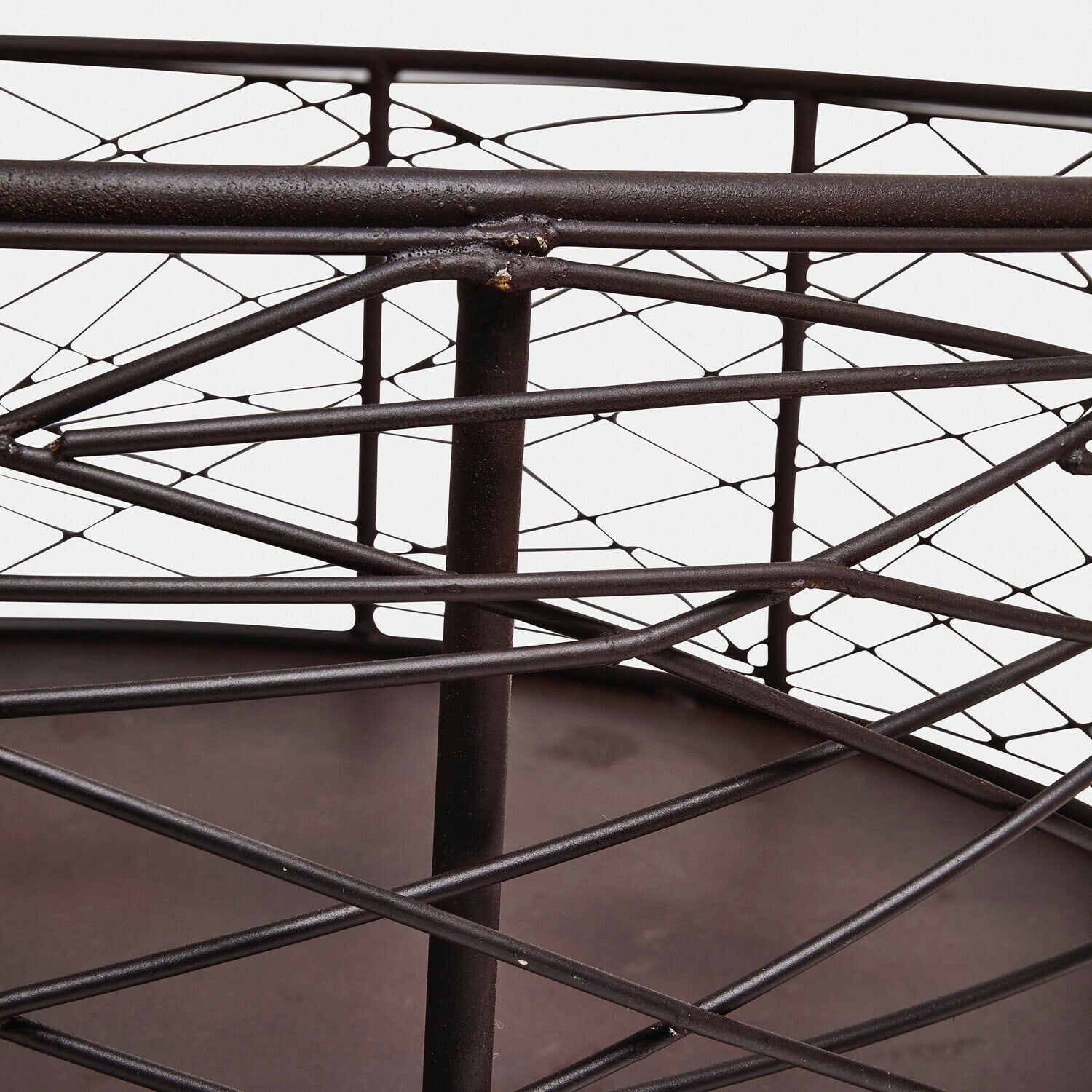 Dunkler Metallkorb mit geometrischem Muster und stabiler Konstruktion als Dekoration