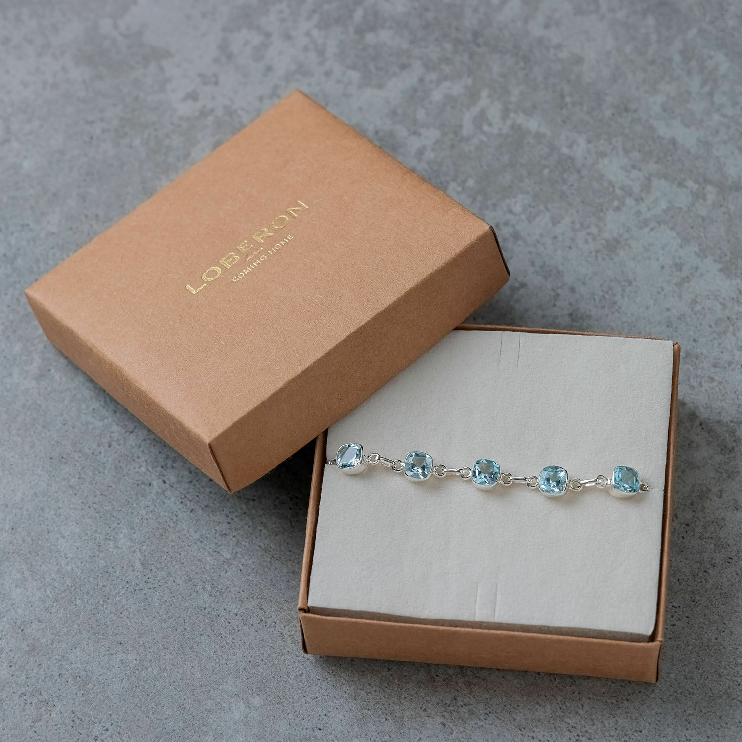 Armband mit blauen Steinen in silberner Fassung in brauner Kartonbox