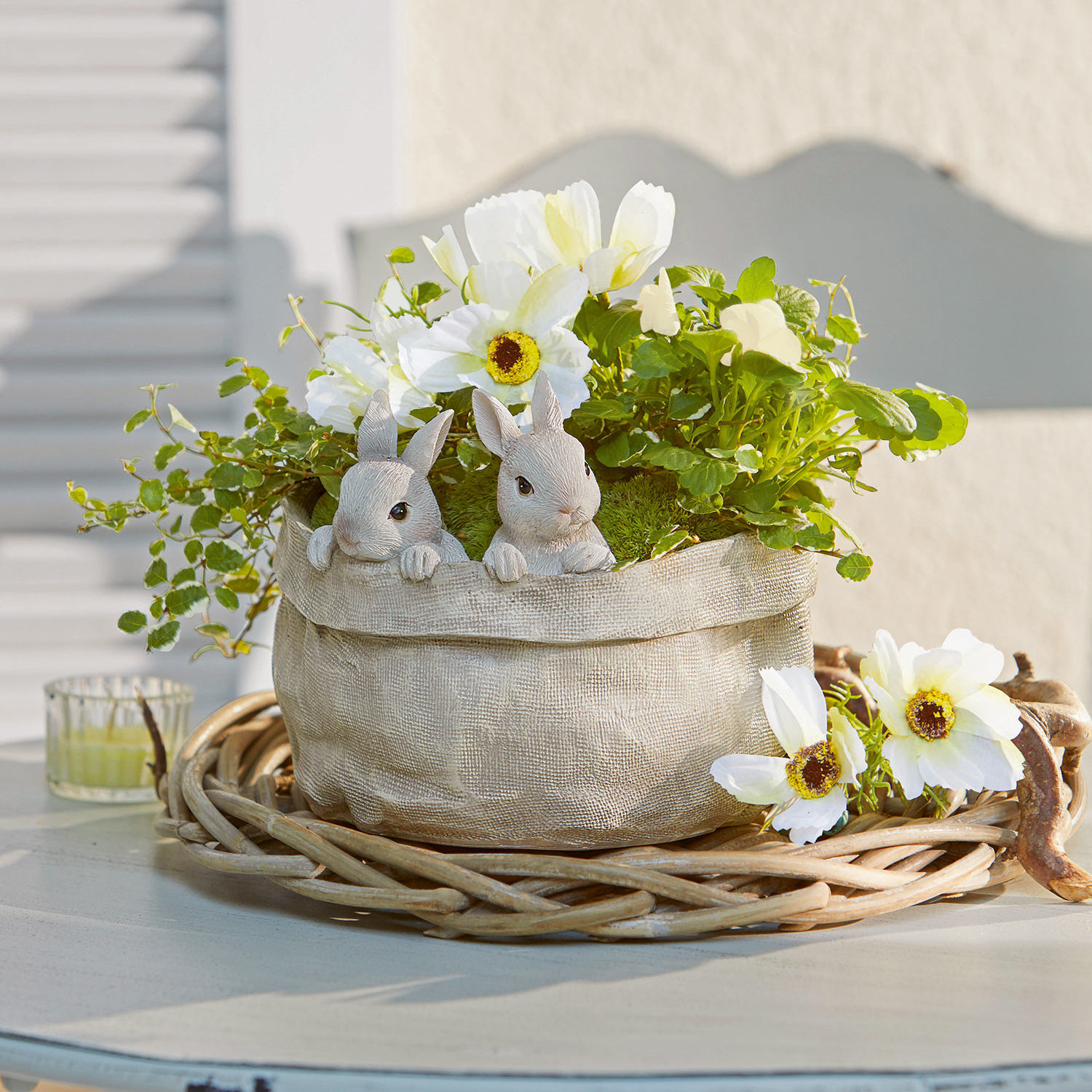 Übertopf Mouriel Dekorativer Beuteltopf aus Stoff in Beige mit weißen Blumen und Hasenfiguren auf einem Weidenkorb