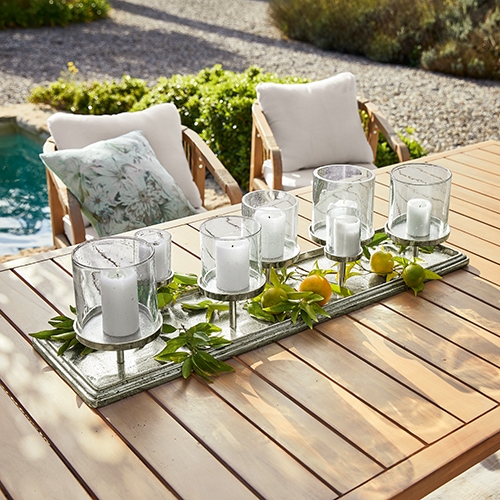 Dekorativer Kerzenhalter aus Holz und Glas für 6 Kerzen auf Gartentisch, natürlicher Stil mit grünen Blättern