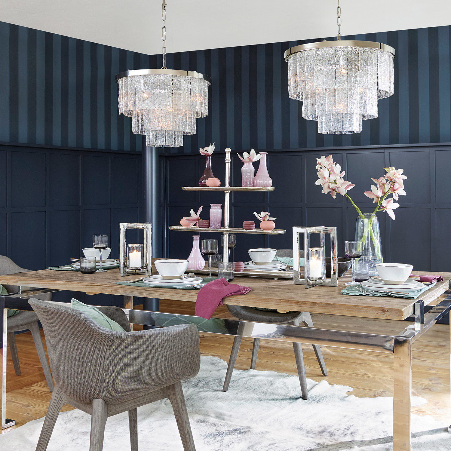 Modernes Esszimmer mit Holztisch, gläsernen Kronleuchtern und pastellfarbenen Dekorationen