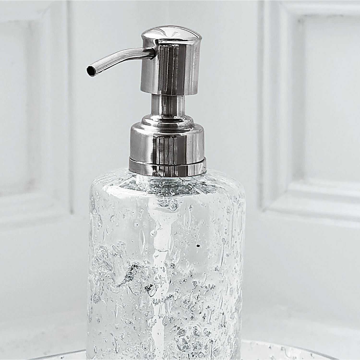 Transparenter Seifenspender aus Glas mit silberner Metallpumpe für das Badezimmer