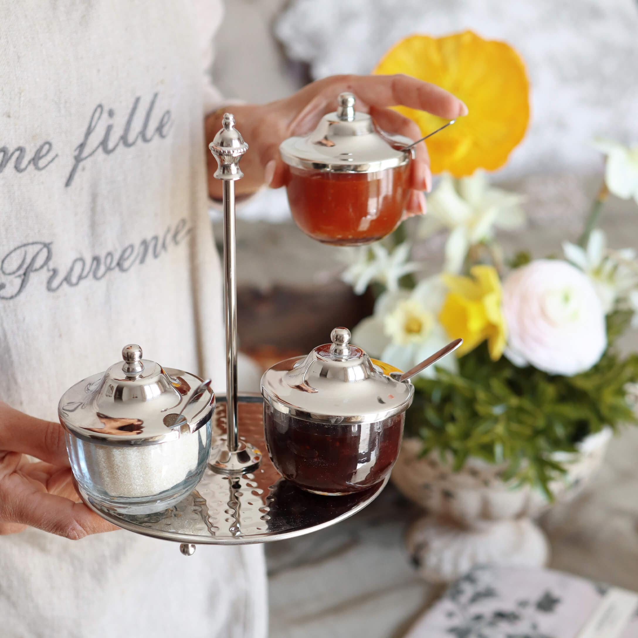 Glasbehälter mit Metalldeckeln auf Metalltablett, gefüllt mit Marmelade und Zucker