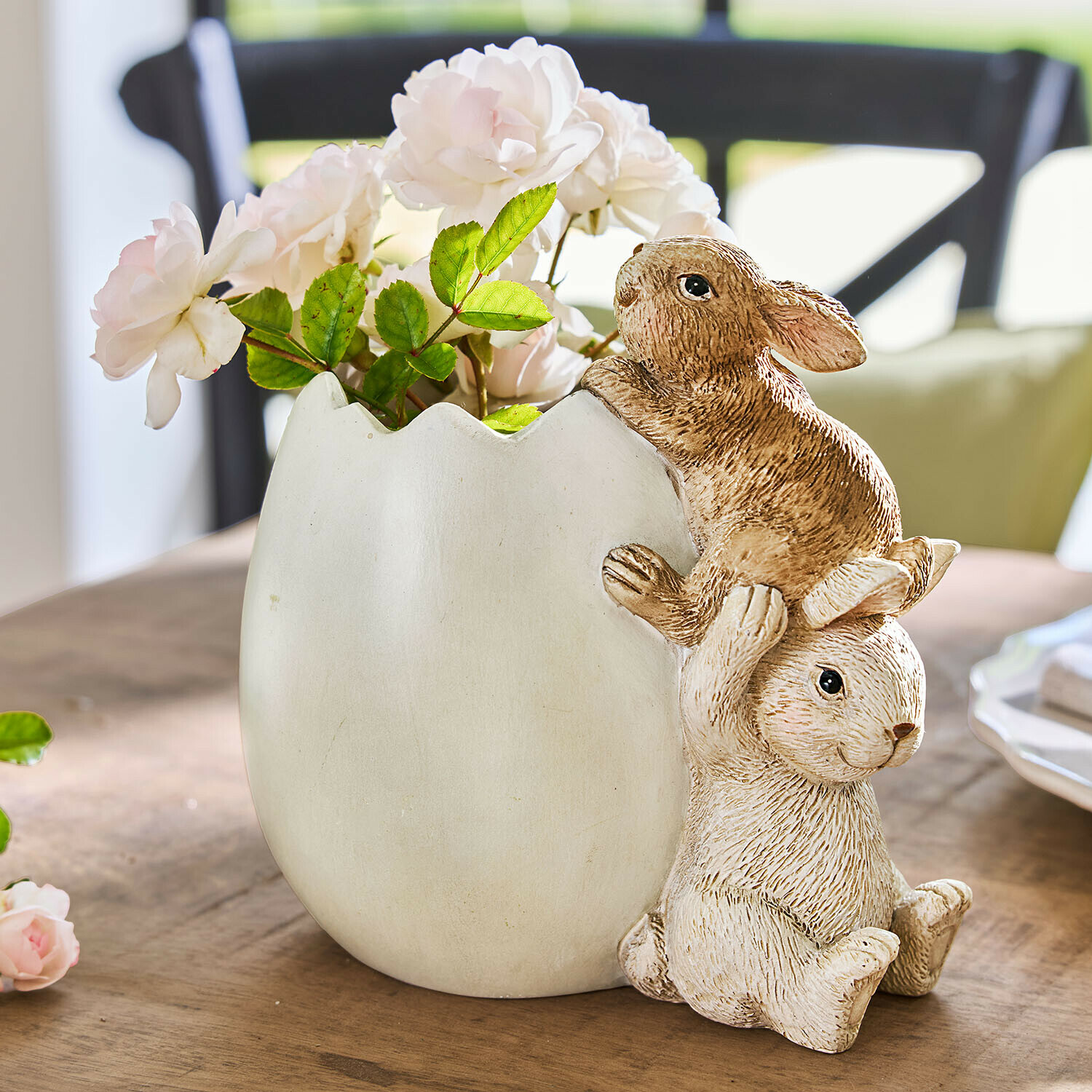 Ei mit Hasen Willowmare Weiße Keramikvase in Eierschalenform mit zwei Hasen und rosa Blumen auf Holztisch