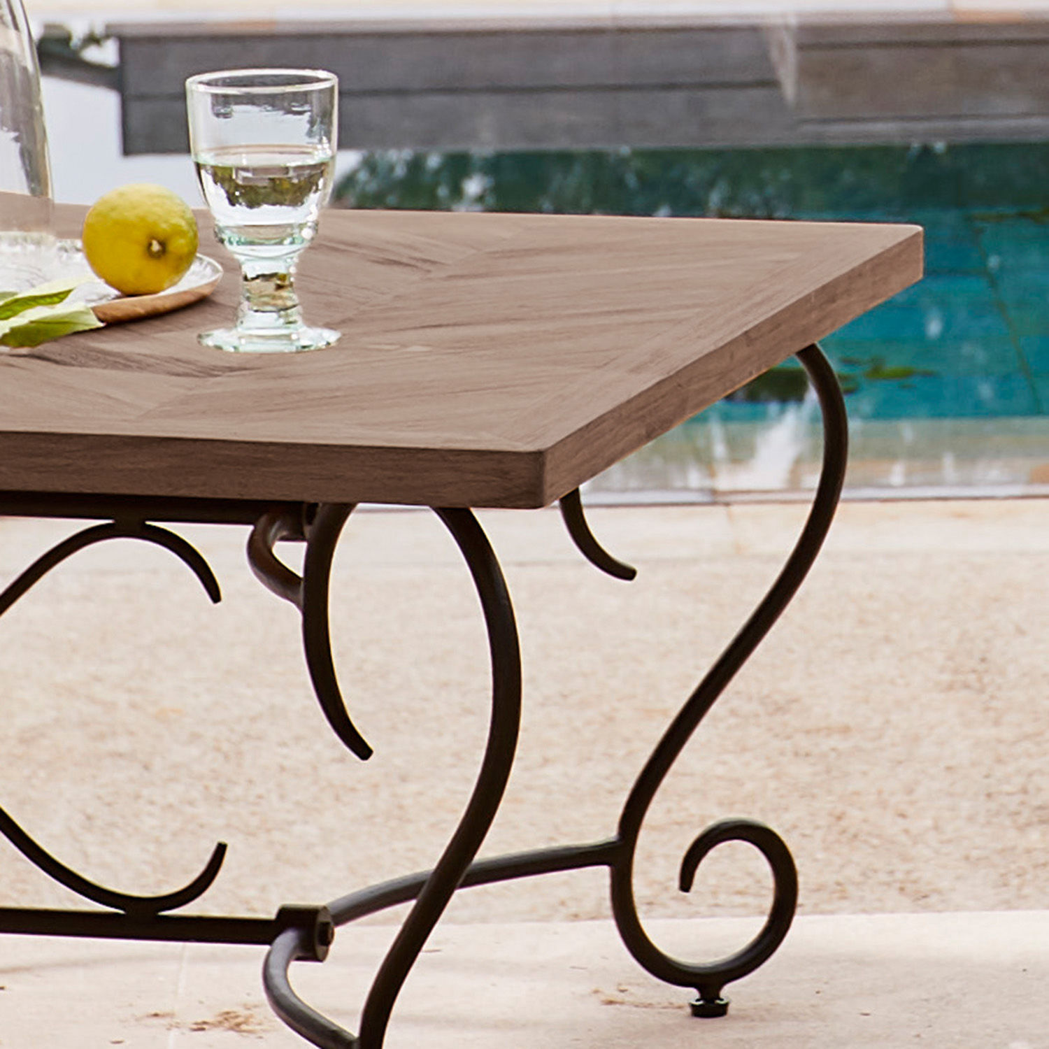 Gartentisch mit Holzplatte und geschwungenen Metallbeinen im Vintage-Stil am Pool
