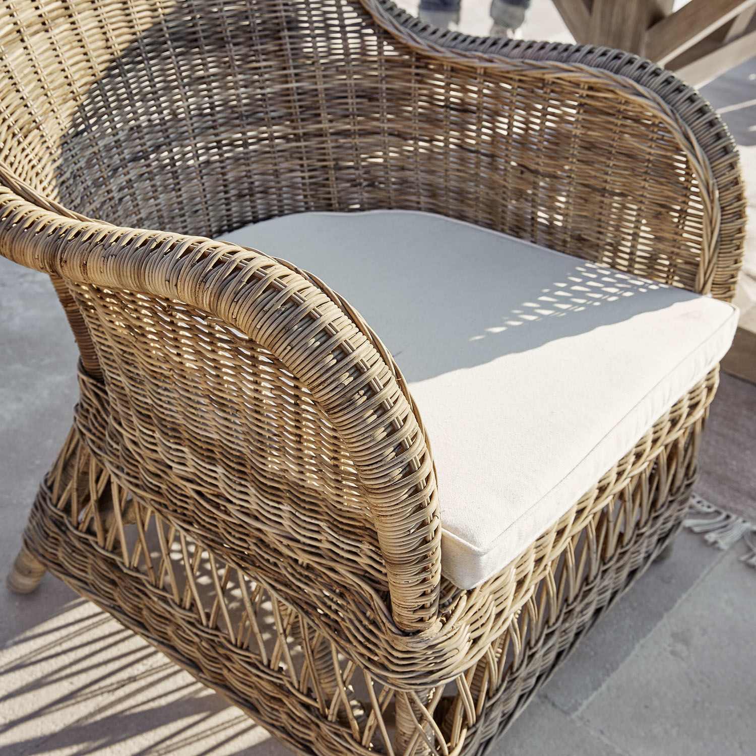Rattansessel mit hellbeigem Polster, ideal für Terrasse oder Balkon, natürlicher Werkstoff