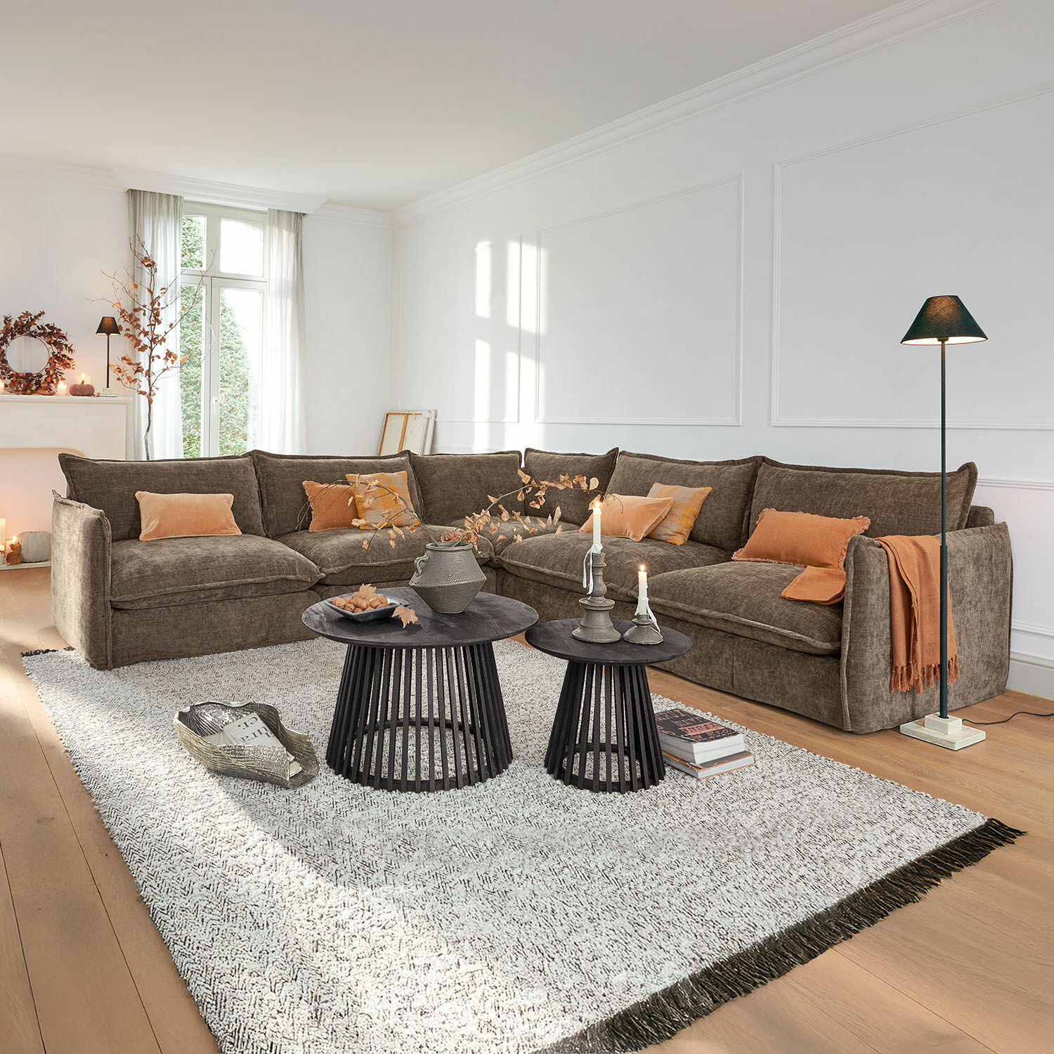 Sofa Illingworth Gemütliche braune Eckcouch aus Stoff mit orangen Kissen und schwarzen Beistelltischen im Wohnzimmer