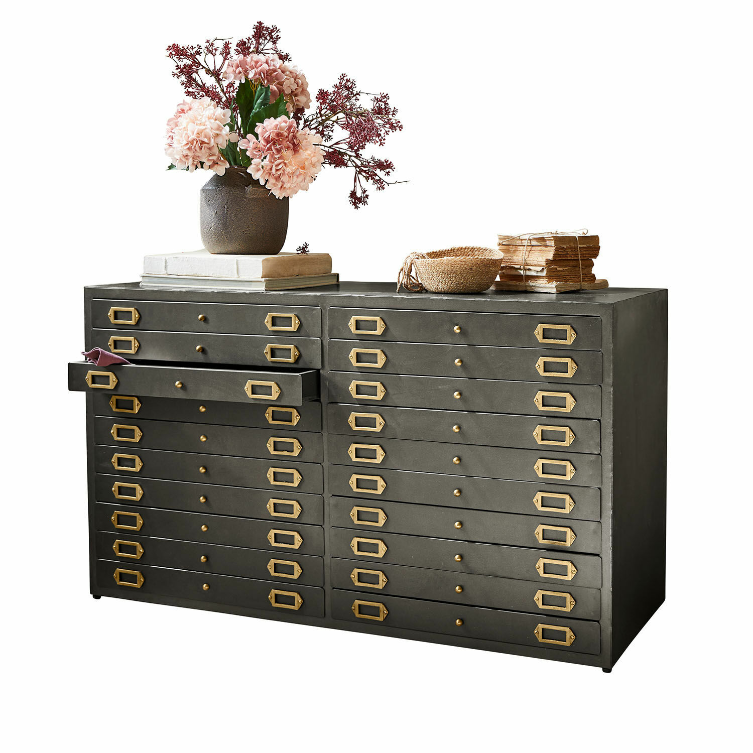 Metallkommode mit vielen Schubladen und Messinggriffen, dekoriert mit Blumen und Büchern