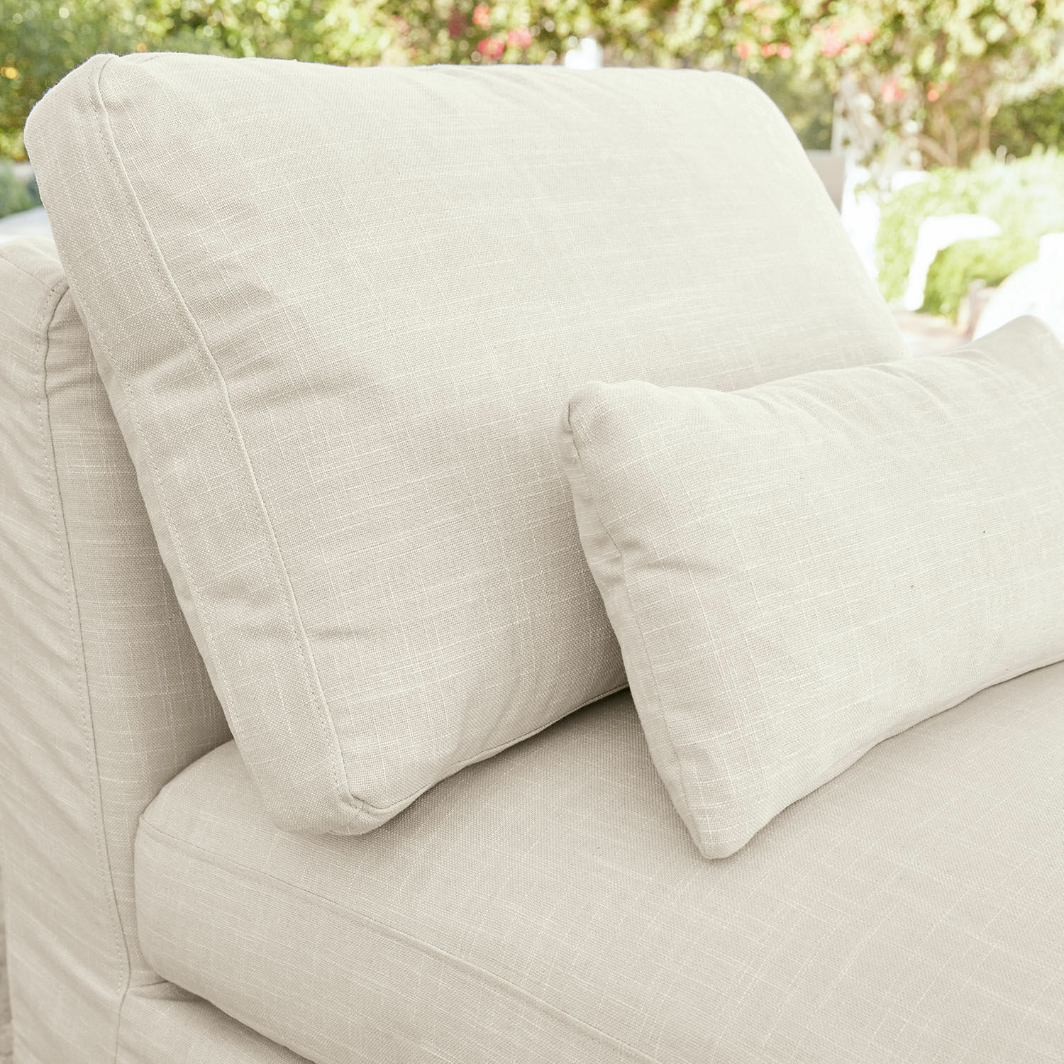 Beige Sofa mit weichem Stoffbezug und zwei Kissen, ideal für gemütliches Wohnen