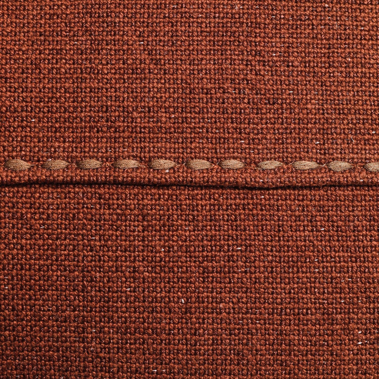 Brauner grob gewebter Stoff mit sichtbarer Naht, dekoratives Textil für Innenräume