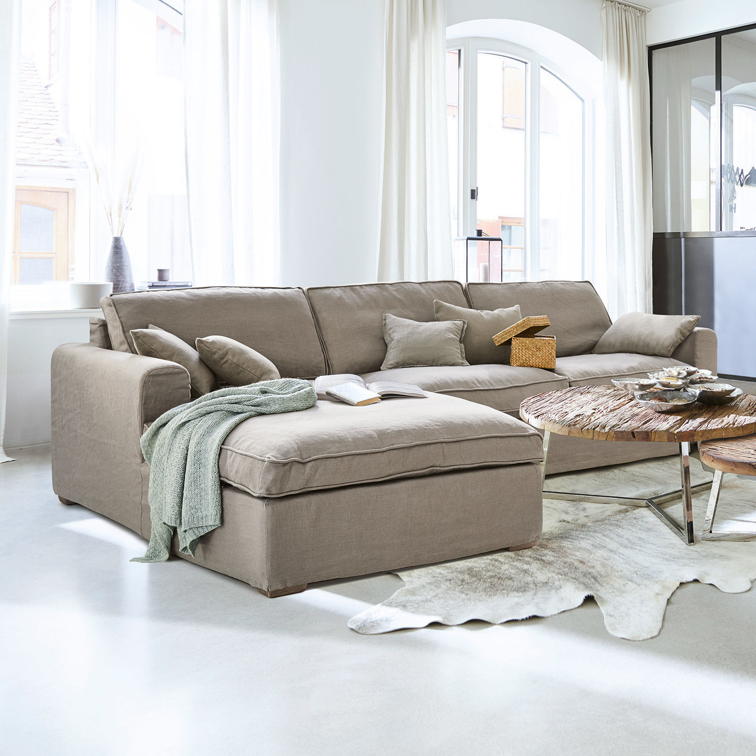 Sofa Seaford Beige Ecksofa aus Stoff in hellem Wohnzimmer mit Holztisch und Dekorationen