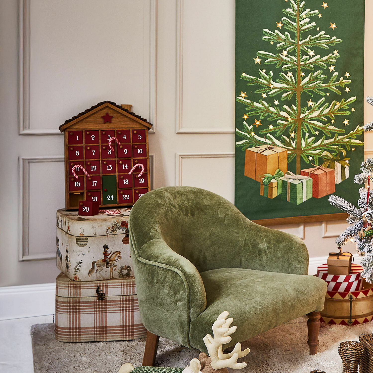Grüner Samtfotel im Vintage-Stil neben Adventskalender und festlicher Weihnachtsdekoration