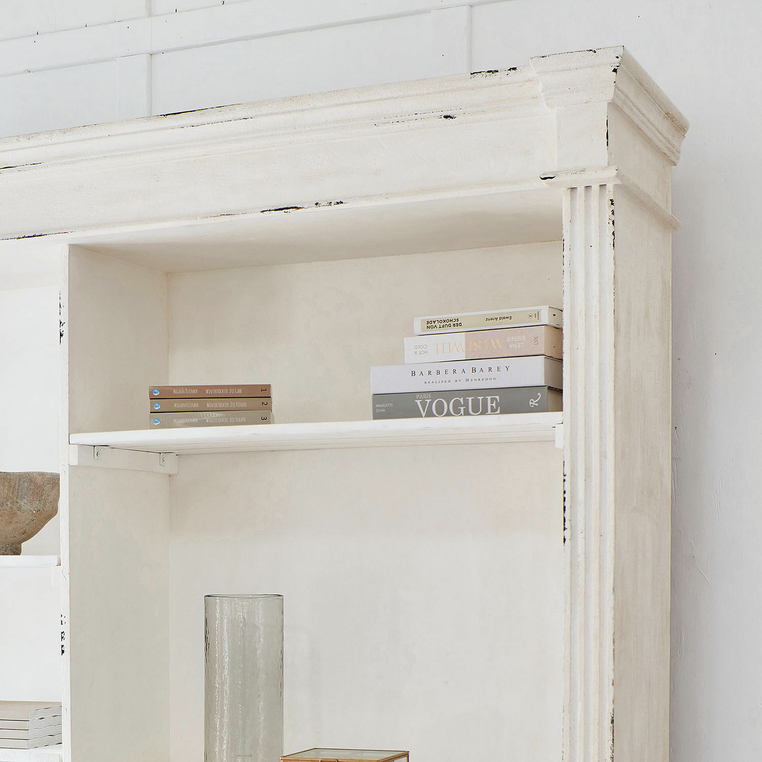 Weißes Holzregal mit dekorativen Büchern, Vintage-Stil, elegantes Wohnzimmermöbel