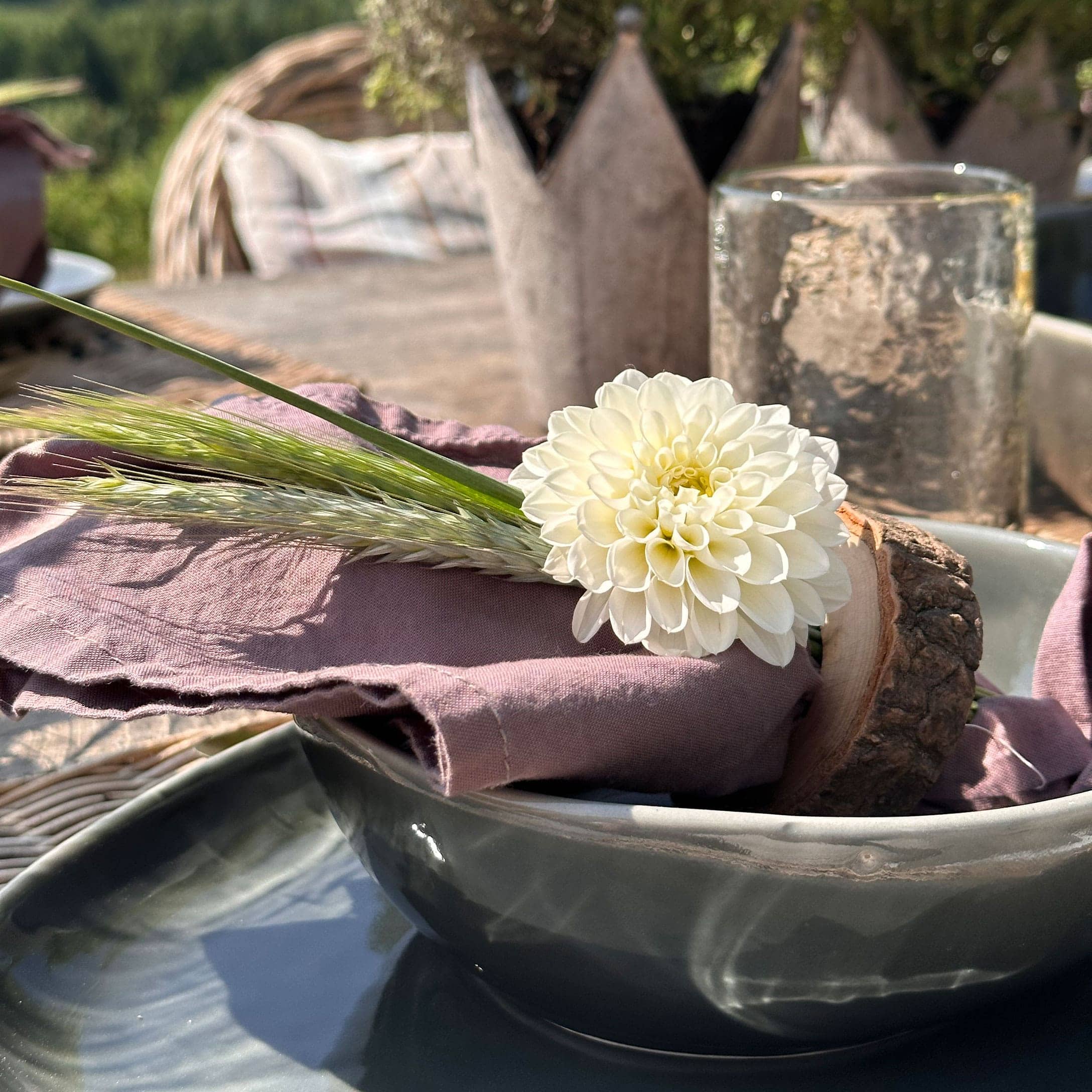 Weiße Blumen-Dekoration auf rosa Leinenserviette mit rustikalem Holzring