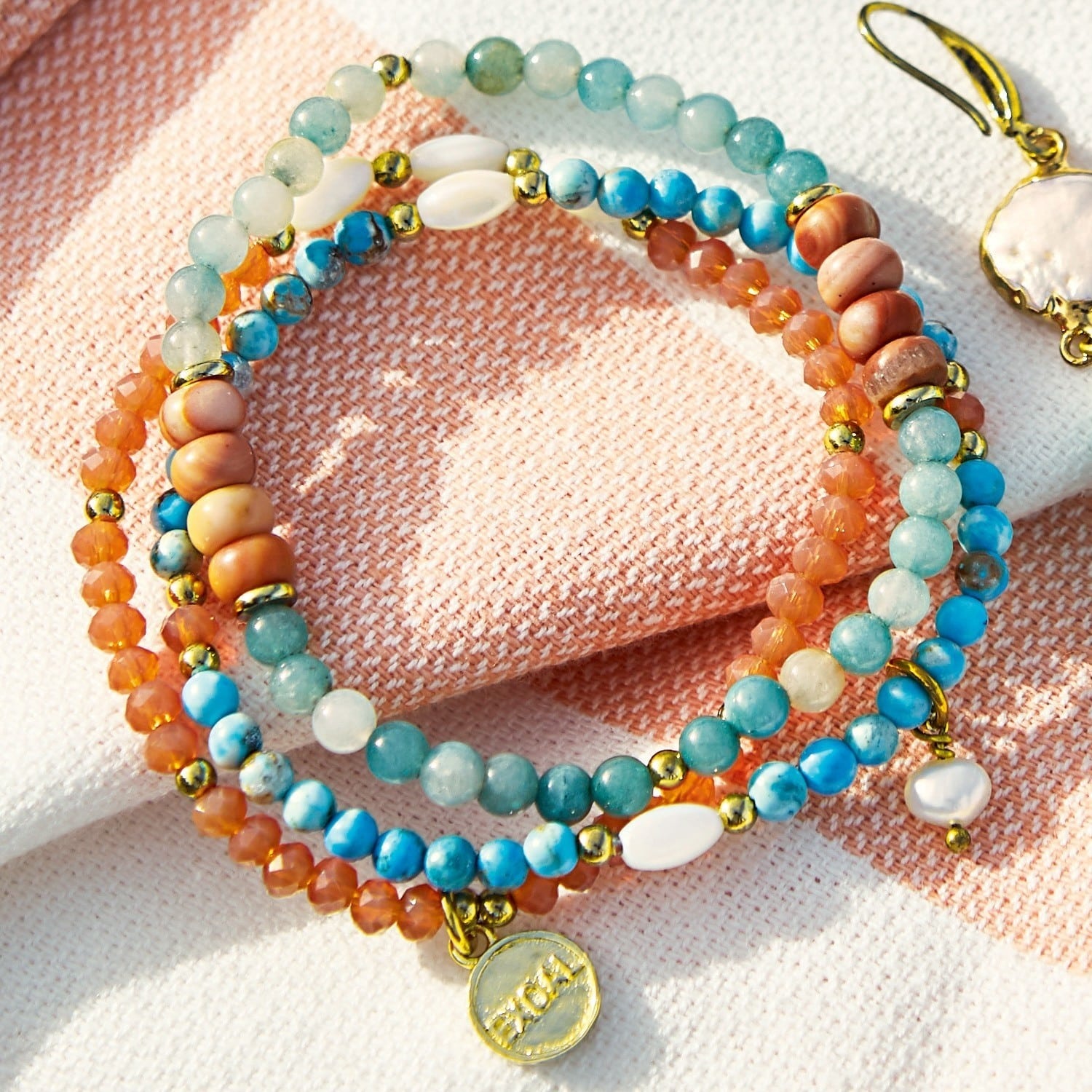 Armband 3er Set Pía Bunte Armband aus Natursteinen mit goldfarbenen Elementen auf hellem Hintergrund, Damenschmuck