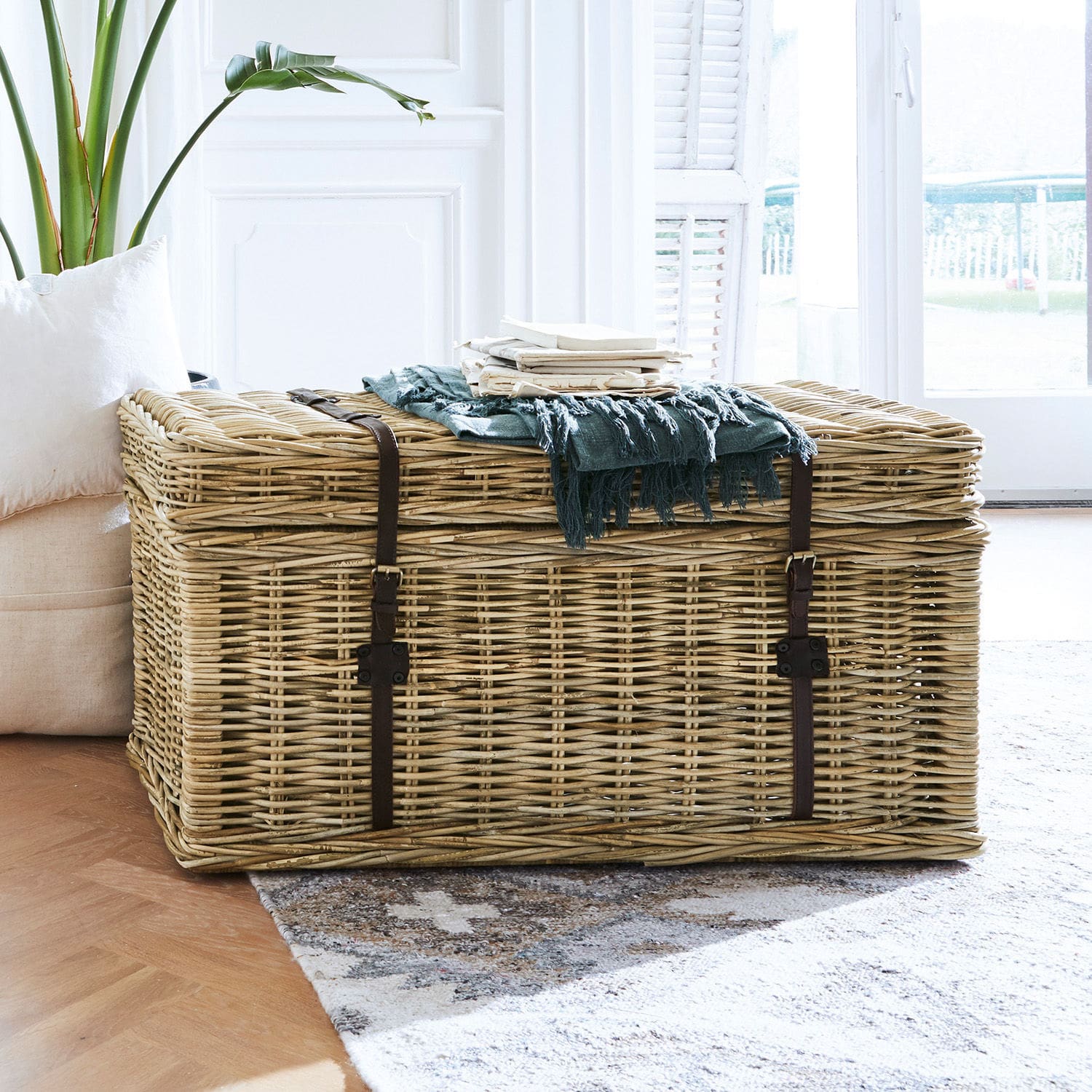 Große Rattankiste in Naturfarbe mit Kunstlederriemen, dekorativ und praktisch zur Aufbewahrung