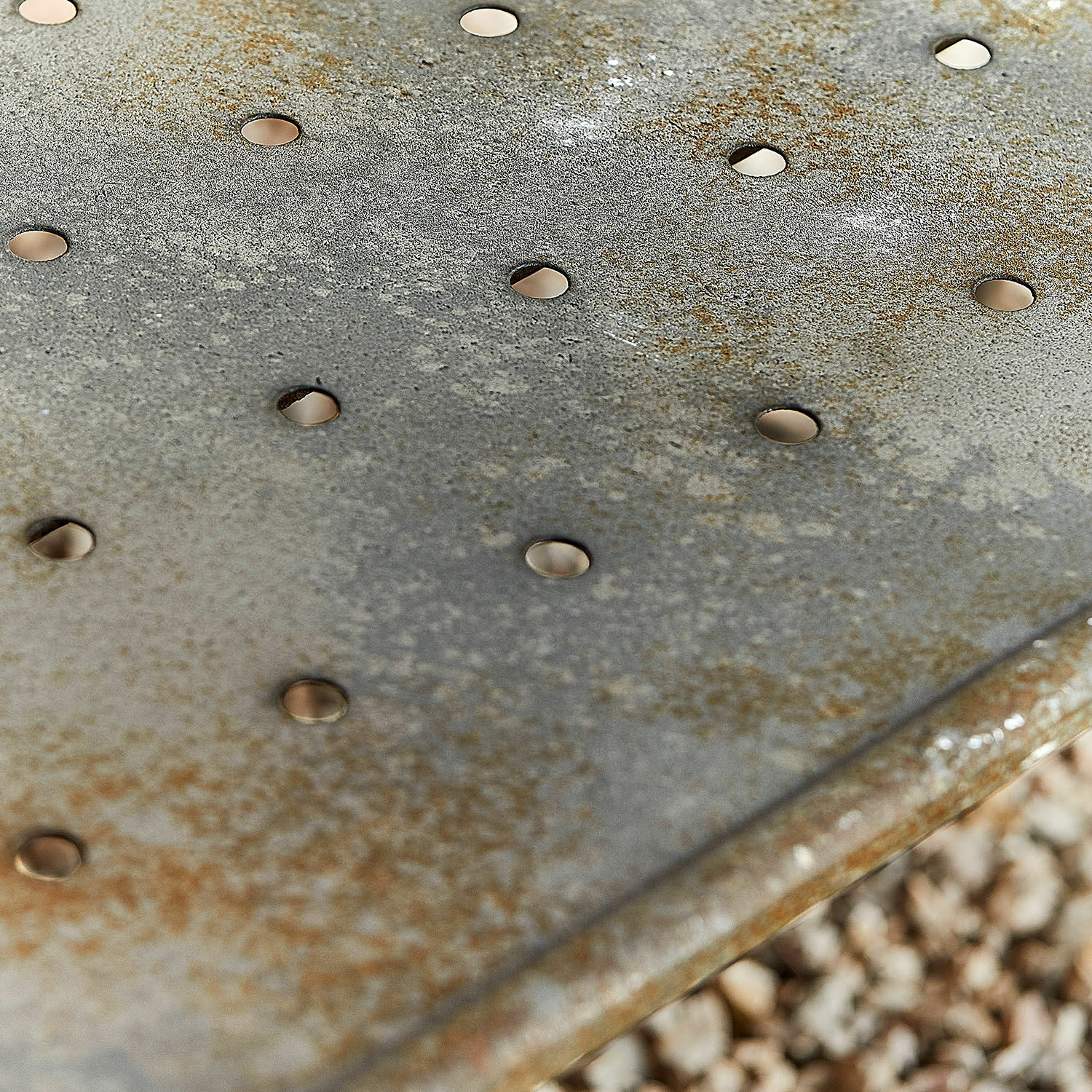 Metallplatte mit Rostflecken und Löchern, grauer, gealterter Look im industriellen Stil