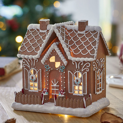 Dekoratives Lebkuchenhaus mit weißer Zuckerglasur und Beleuchtung, ideal für Weihnachtsdeko