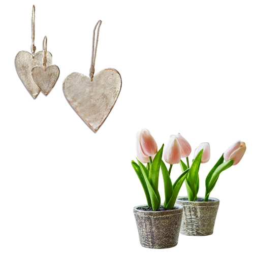 Dekorative silberne Metallherzen und künstliche Tulpen in Töpfen als Frühlingsdeko