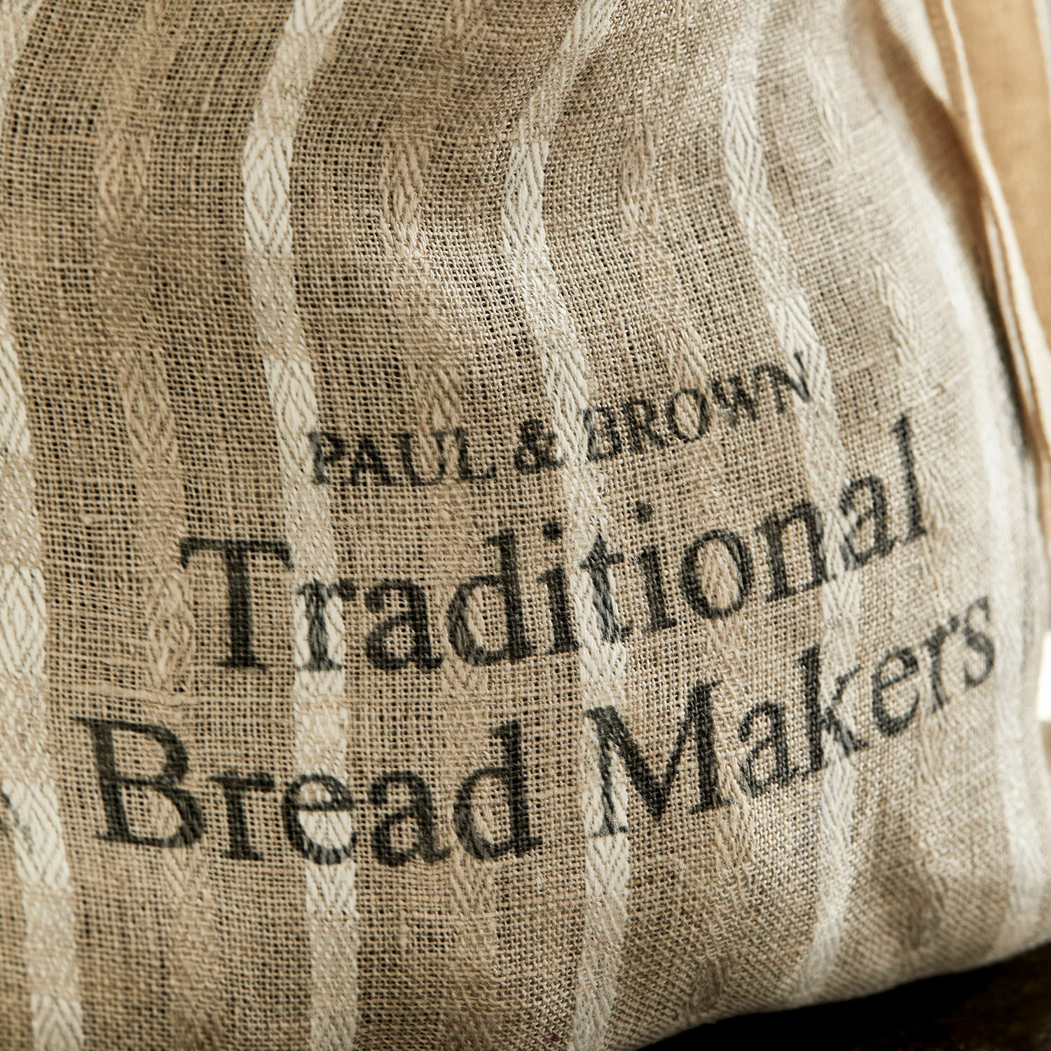 Beiger Leinen-Brotbeutel mit Aufdruck Traditional Bread Makers, sichtbare Stoffstruktur.