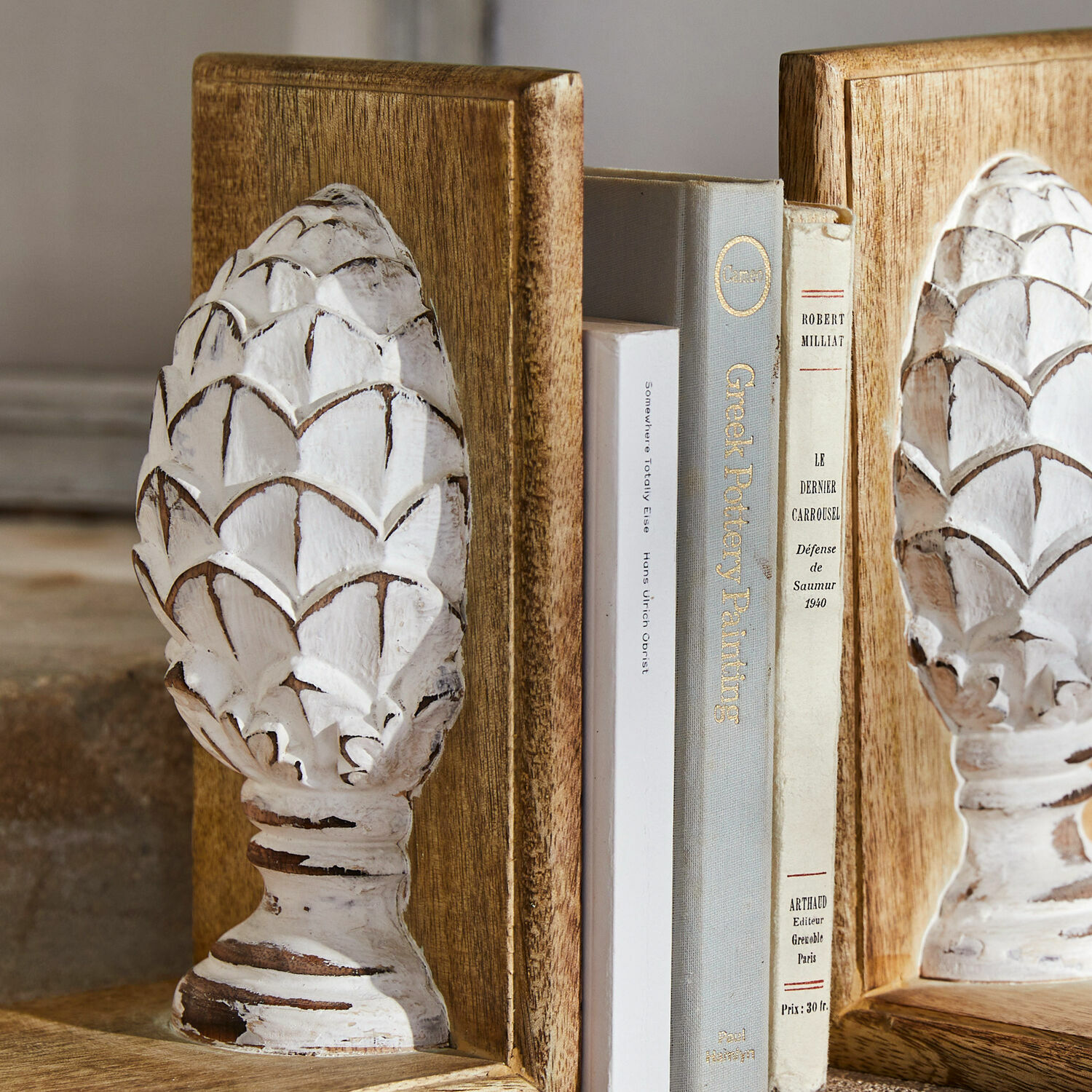 Holz-Buchstützen mit weißer, antik wirkender Patina und Zapfen-Dekor im rustikalen Stil