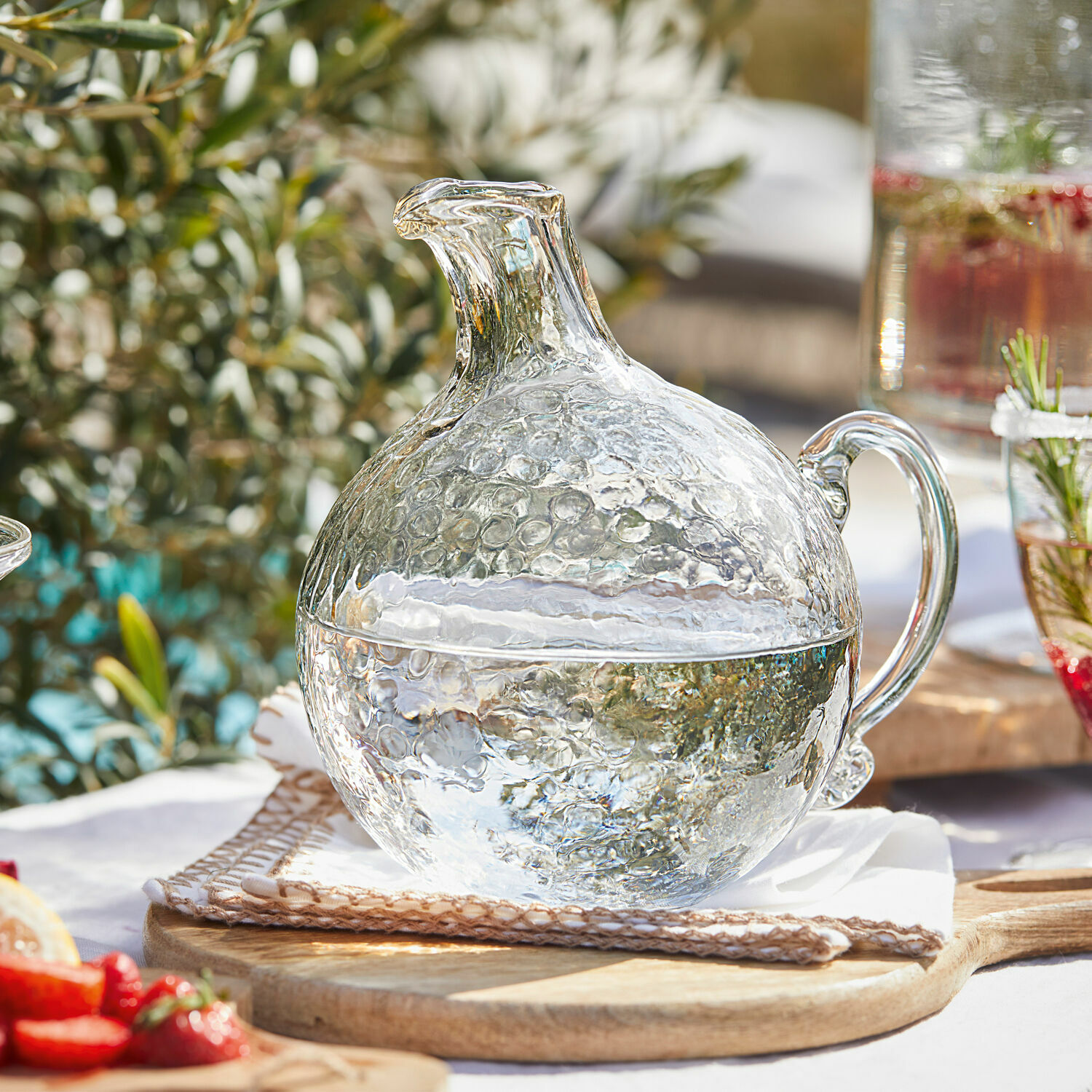 Krug Valters Glaskrug mit Blasenstruktur, transparent, auf Holzbrett, ideal für Getränke und Sommerpartys.