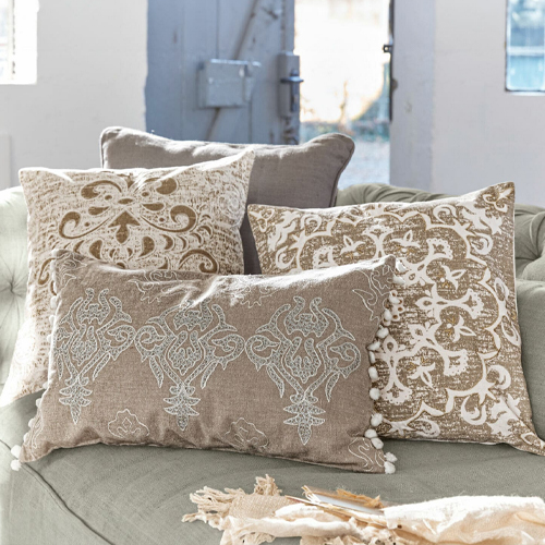 Vier dekorative Kissen in Beige und Weiß mit Mustern auf Sofa, Wohntextilien für Wohnzimmer