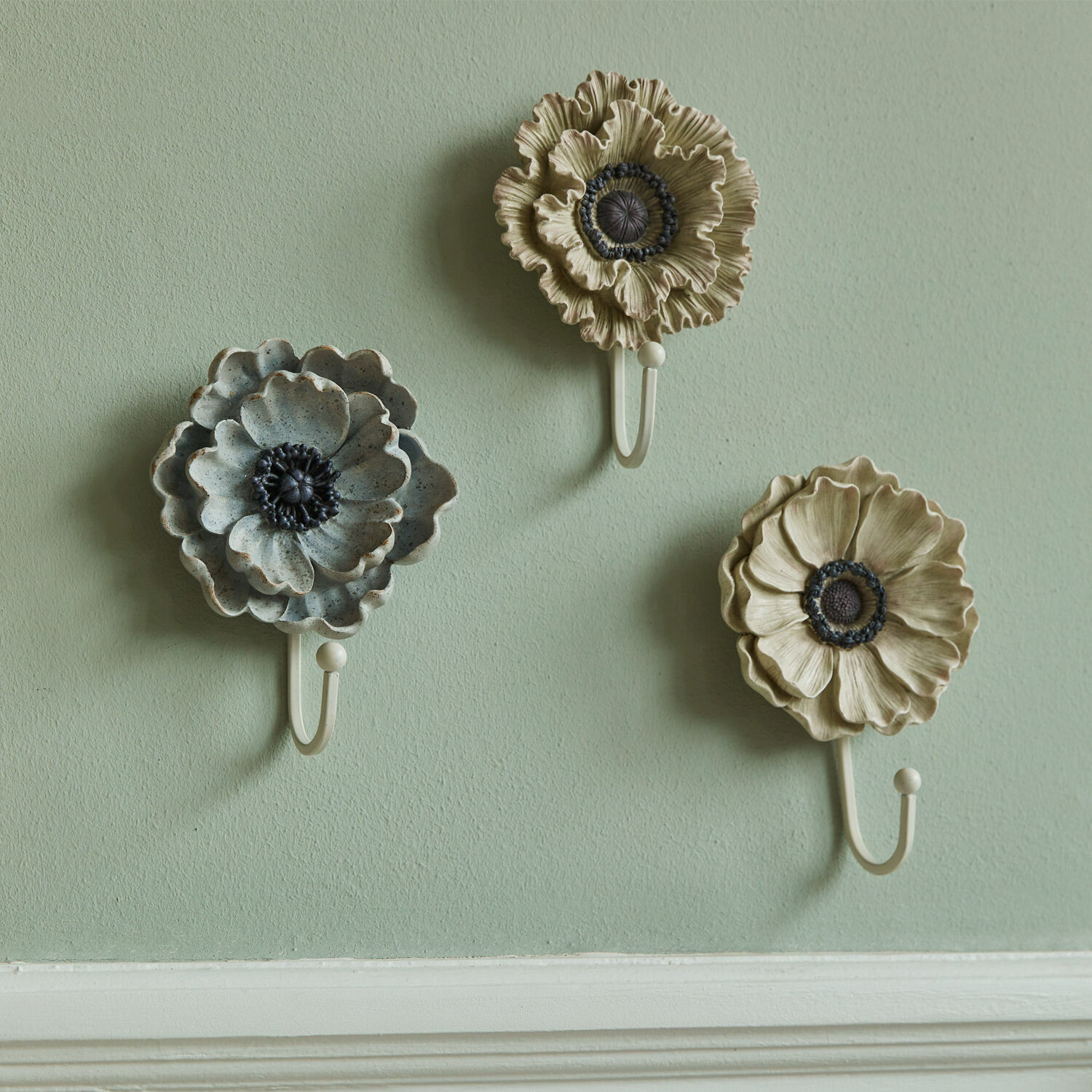 Set aus drei metallischen Wandhaken in Blumenform in Beige und Grau für Wohnraumdeko