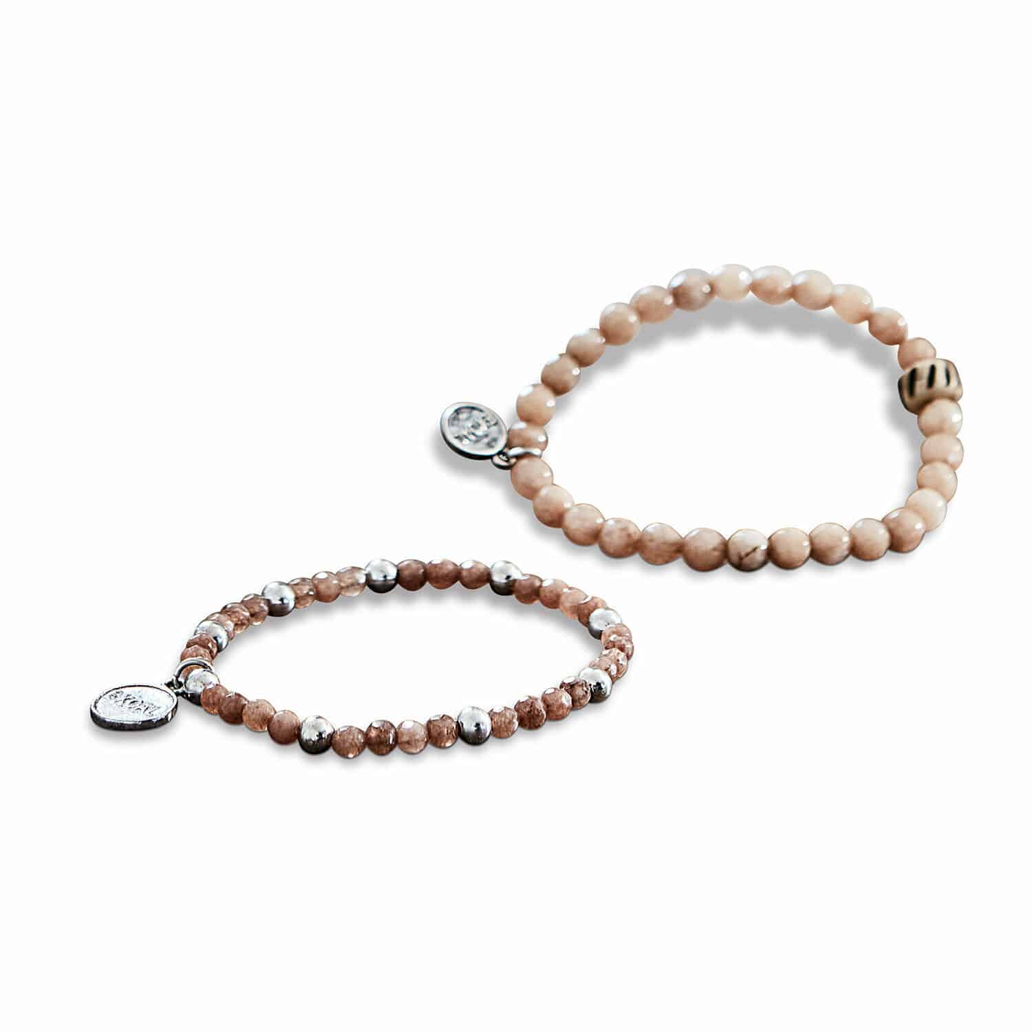 Zwei braune Perlenarmbänder mit Metallanhängern, modischer Damenschmuck.