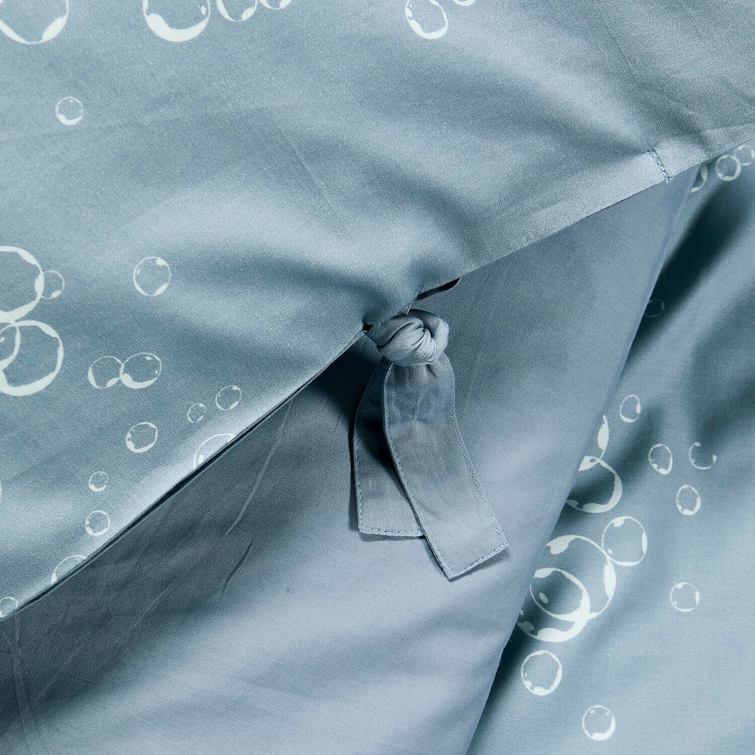 Blaue Baumwoll-Bettwäsche mit weißen Blasenmustern und Bindeband zur Fixierung der Decke