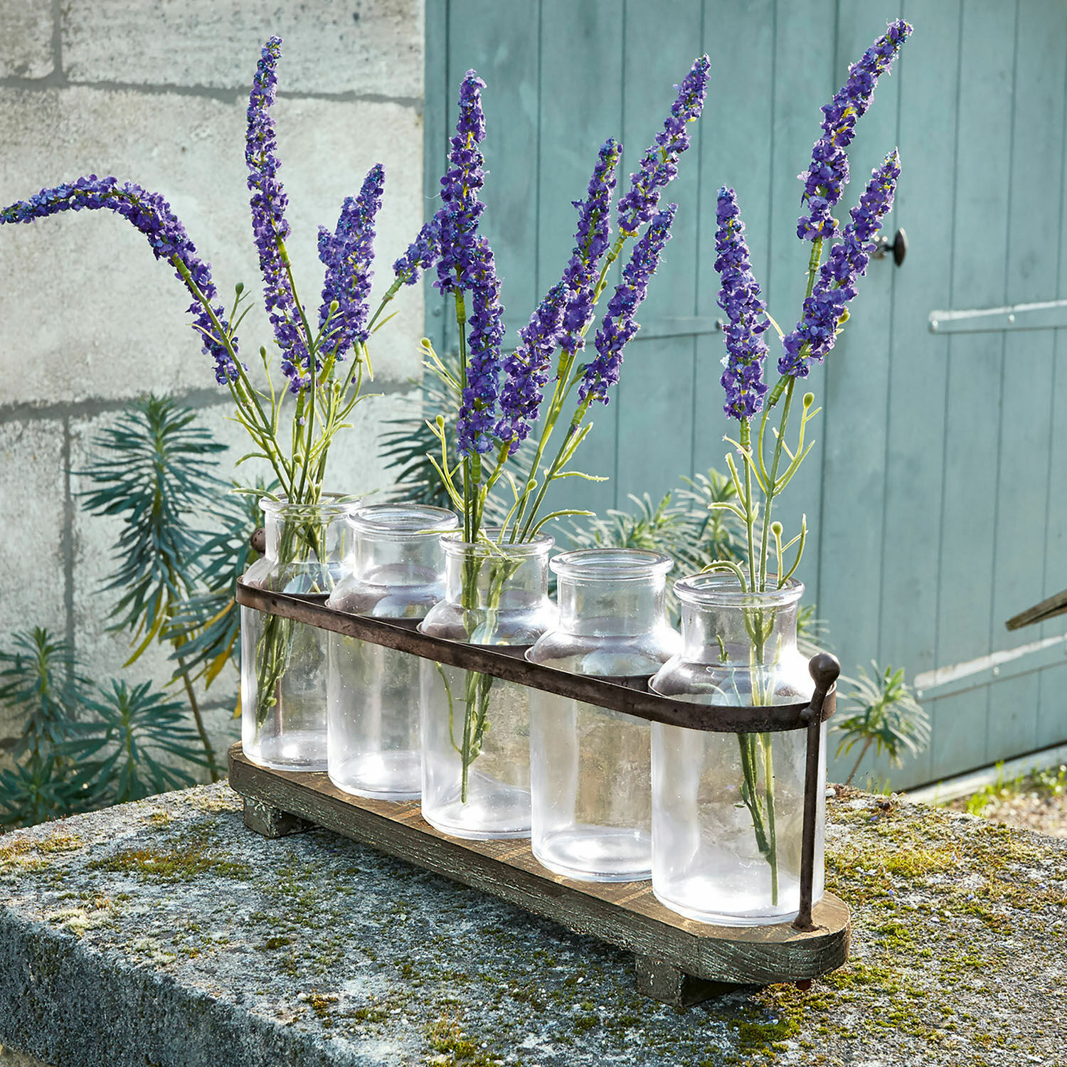 Vase 5er Set Ranjo Set aus fünf transparenten Glasvasen mit Metallhalter auf Holzsockel, dekoriert mit violetten Blumen