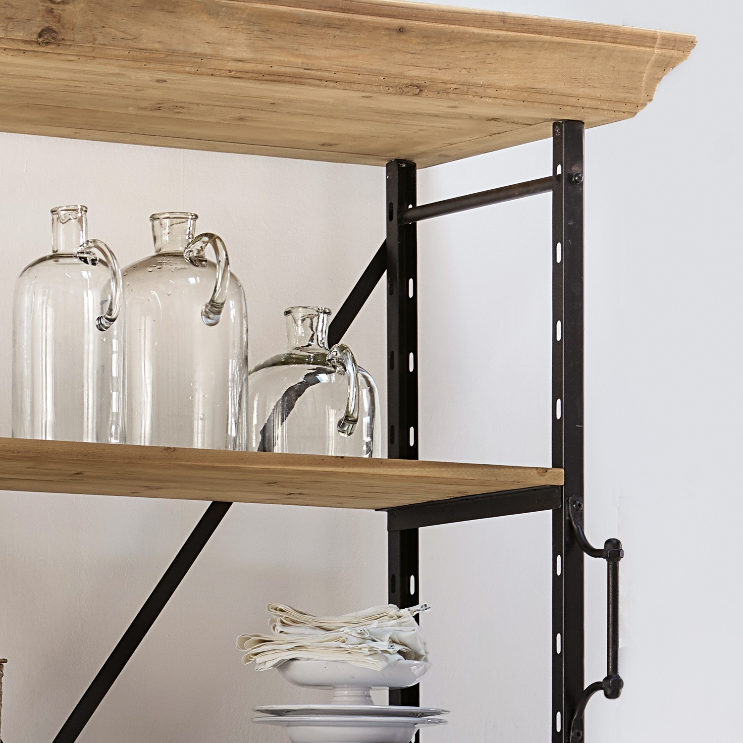 Wandregal aus Holz und Metall im Industriestil mit transparenten Glasflaschen und weißem Geschirr