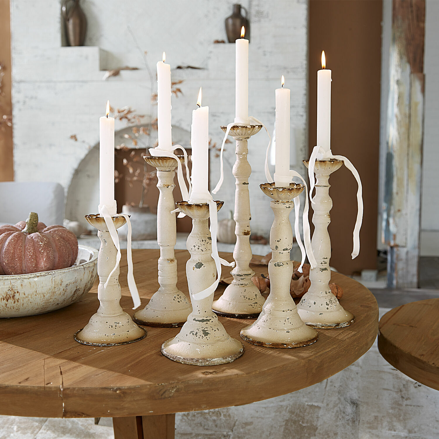 Kerzenhalter 6er Set Rivondelle Set aus sieben cremefarbenen Metallkerzenhaltern mit weißen Kerzen auf Holztisch, Wohnraumdeko