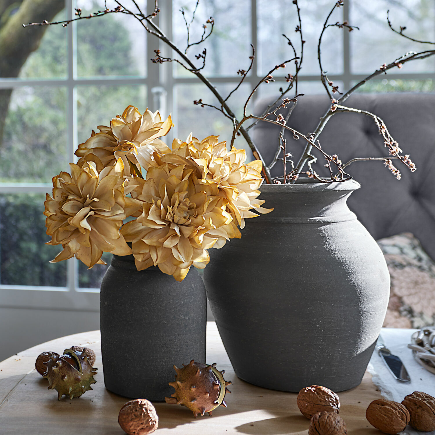Vase 2er Set Molduc Zwei graue Keramikvasen mit getrockneten Blumen und Zweigen auf Holztisch mit Walnüssen
