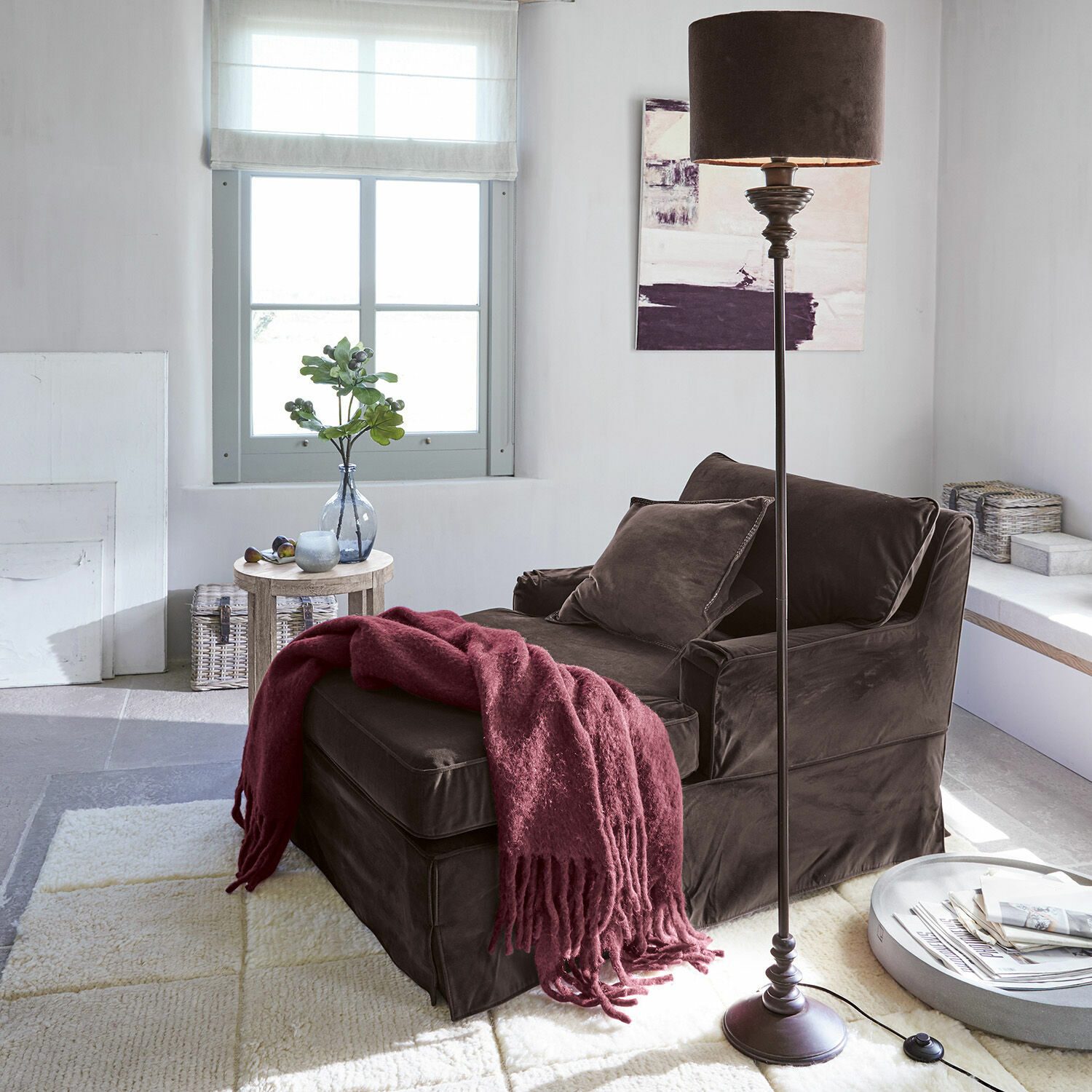 Brauner Samtfotel mit Hocker und bordeauxroter Decke in hellem, modernem Wohnzimmer