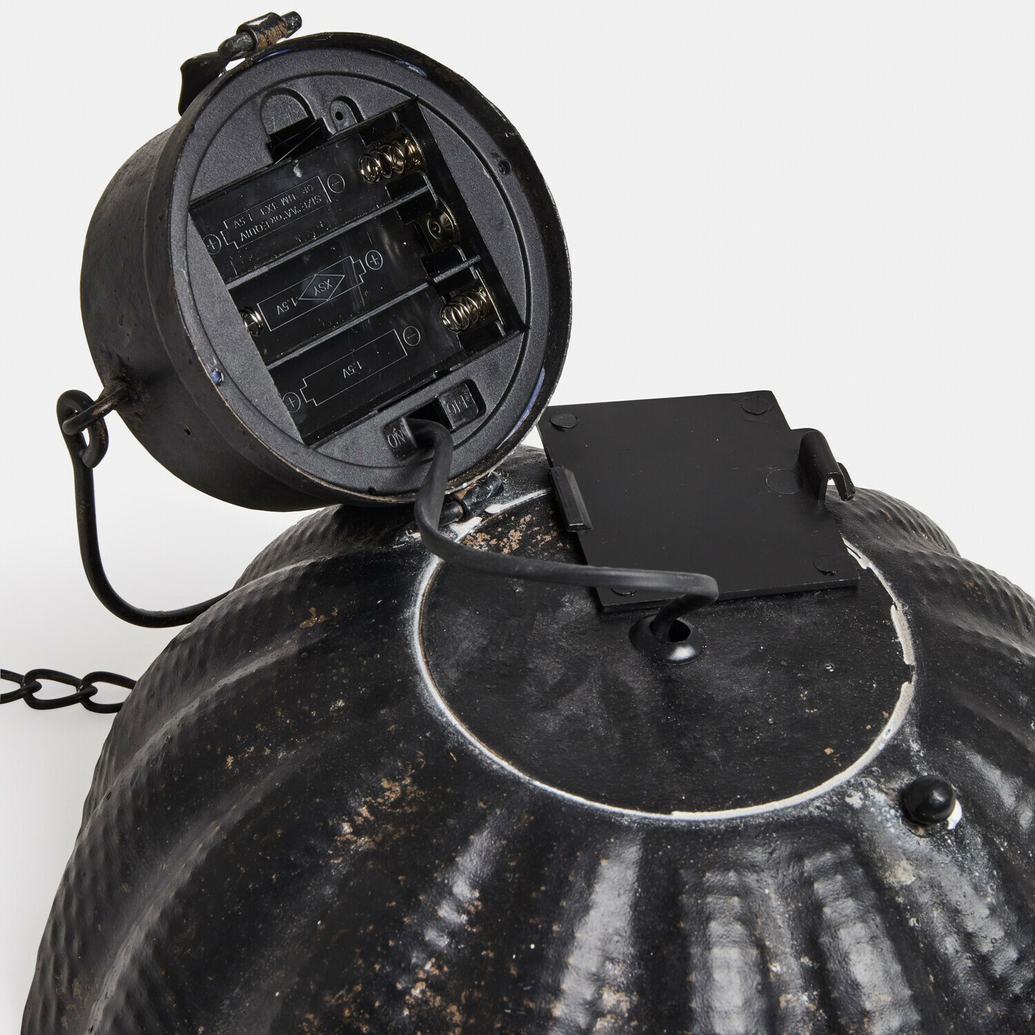 Schwarze Metalllampe mit offenem Batteriefach und Kabel mit Ein-/Ausschalter