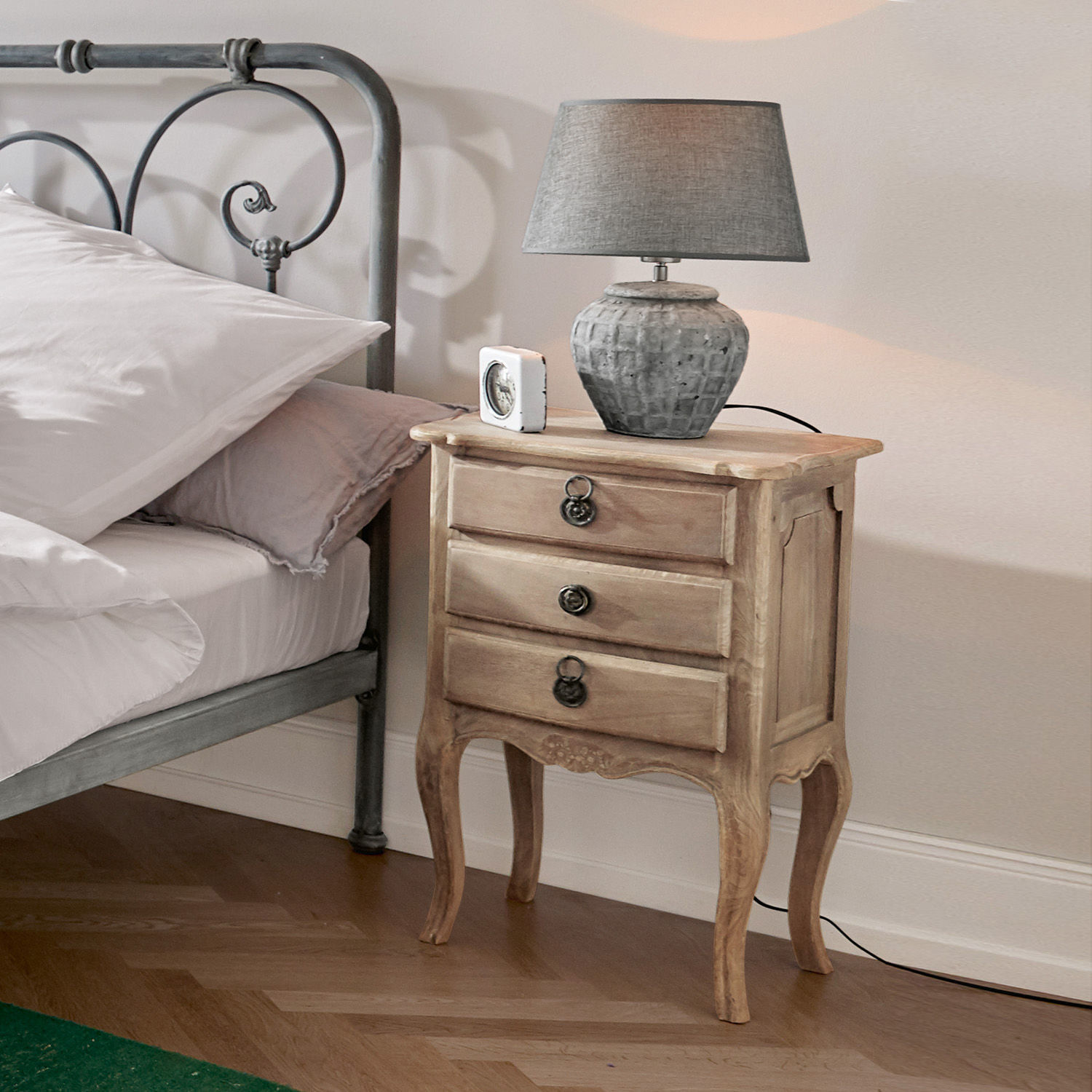 Nachttisch aus hellem Holz mit drei Schubladen und grauem Lampenschirm im Schlafzimmer