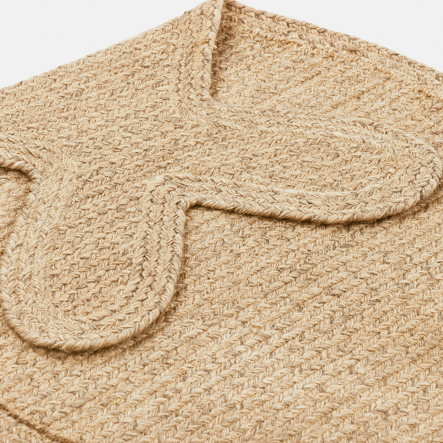 Beige geflochtene Tasche aus Naturmaterial mit sichtbarer Struktur und Klappe