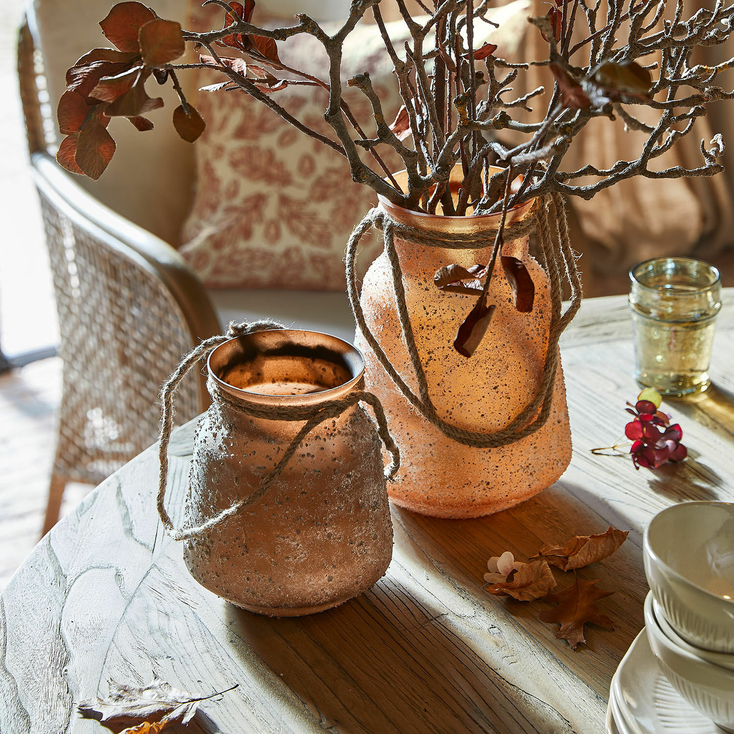 Vase 2er Set Querello Zwei dekorative Vasen aus mattiertem orangefarbenem Glas mit Kordeln auf einem Holztisch im Wohnzimmer