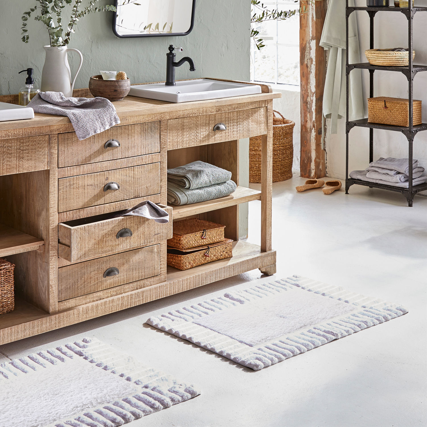 Helles Holz-Badezimmermöbel mit Waschbecken und weichen Teppichen im rustikalen Stil
