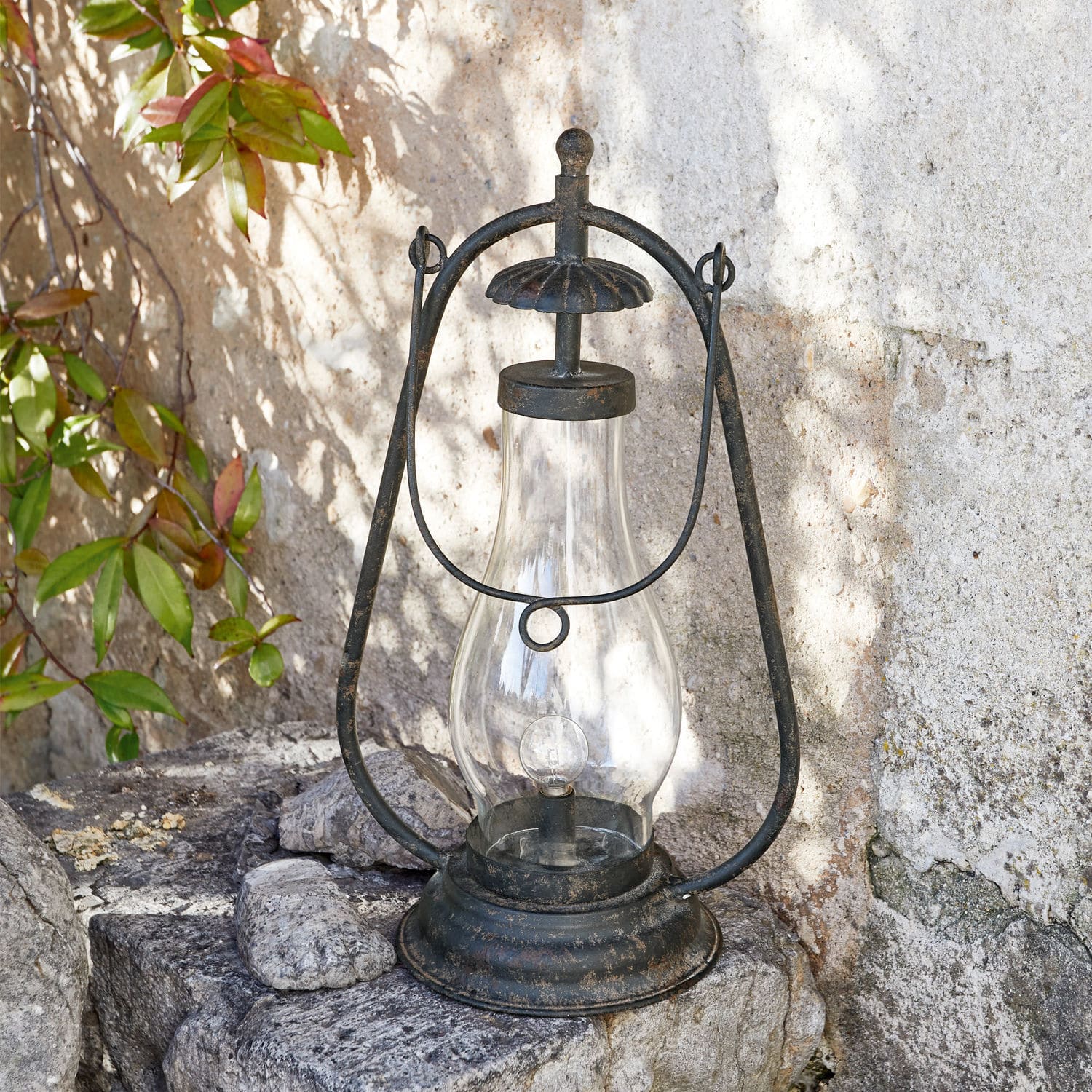 Metall-Gartenlaterne mit klarem Glas und schwarzer Patina auf Stein im Außenbereich
