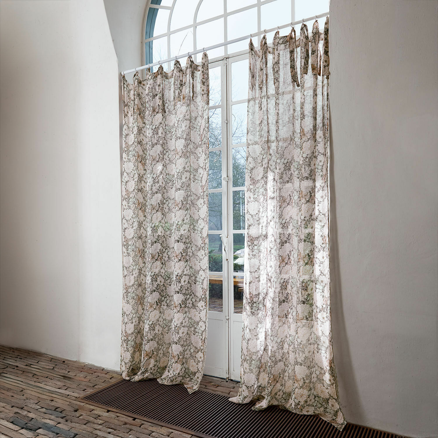 Gardine Cappellina Transparente Vorhänge mit zartem Muster in Beige- und Brauntönen vor weißem Fenster