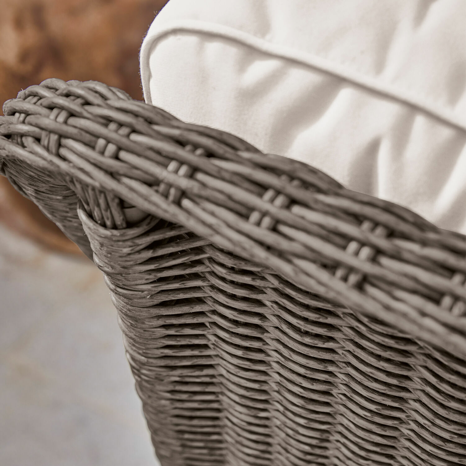 Nahaufnahme eines hellen Polsters auf einem Möbelstück aus natürlichem, beige geflochtenem Rattan