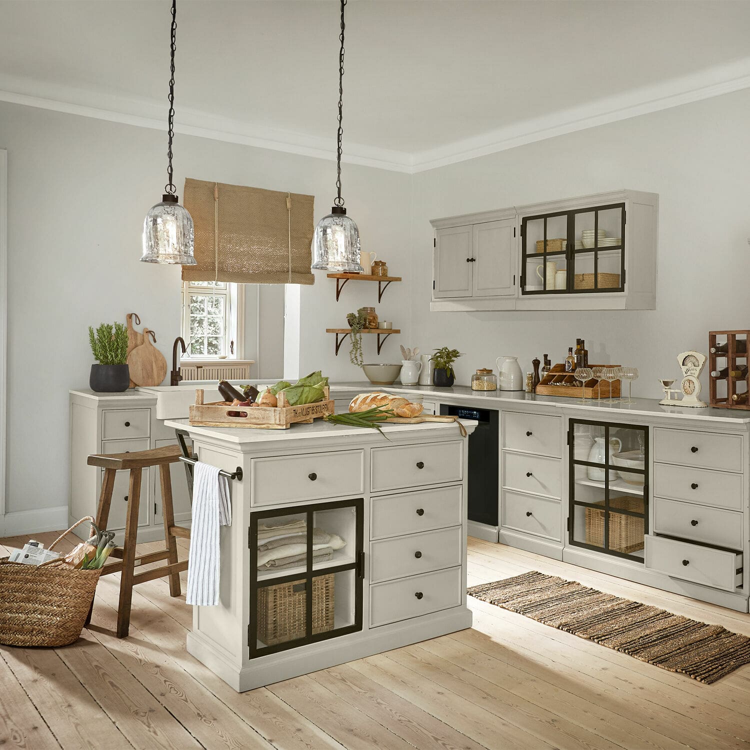 Landhausküche mit grauen Holzschränken und Kücheninsel auf hellem Holzboden
