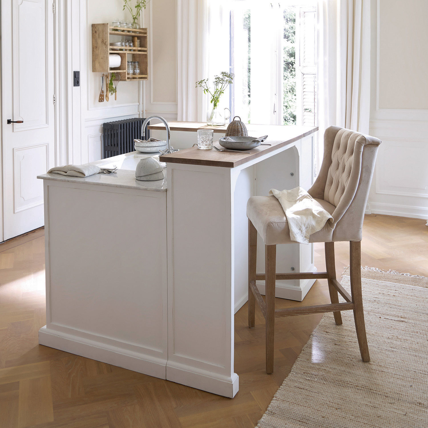 Küche mit weißer Insel, Holzarbeitsplatte und beige gepolstertem Barhocker