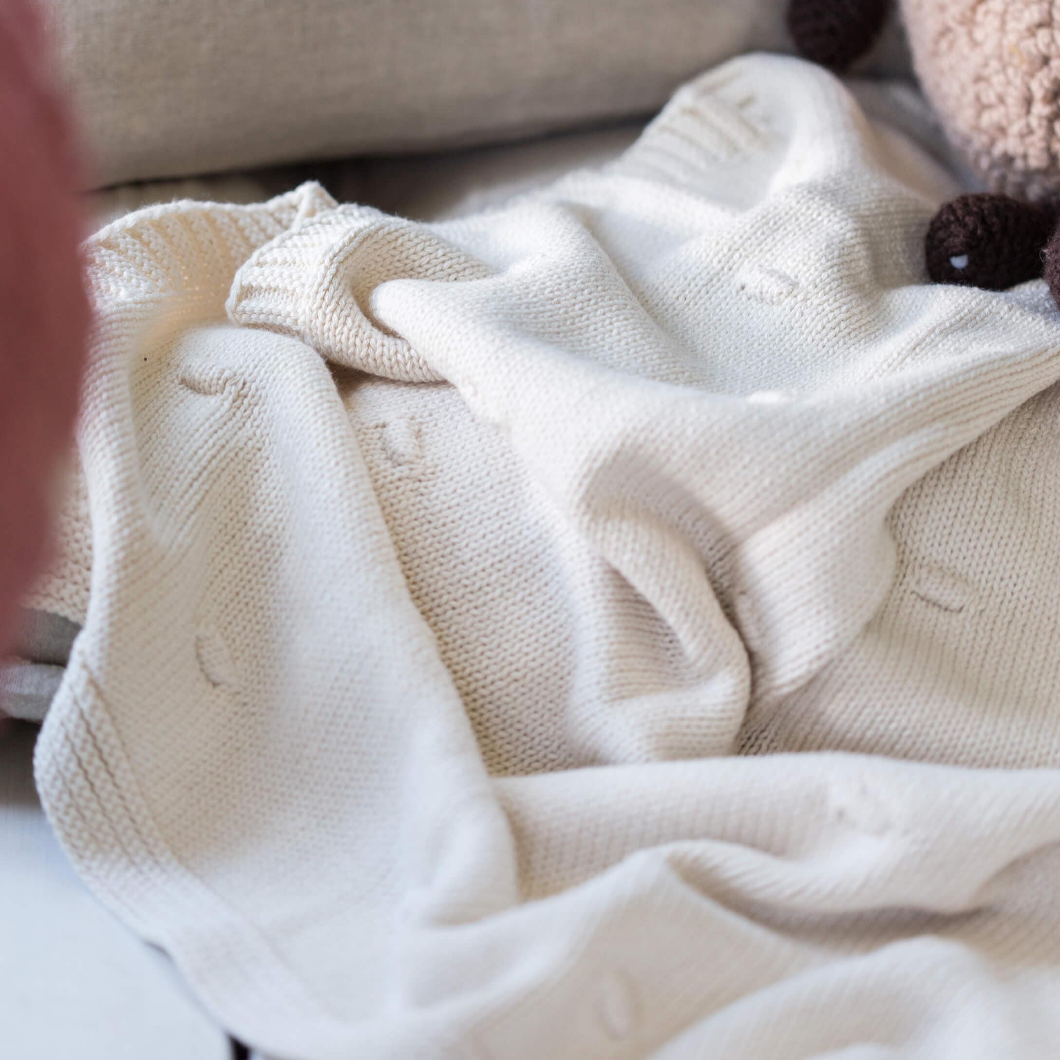 Weiche weiße Strickdecke mit dezentem Muster, ideal für gemütliche Wohnraumdekoration