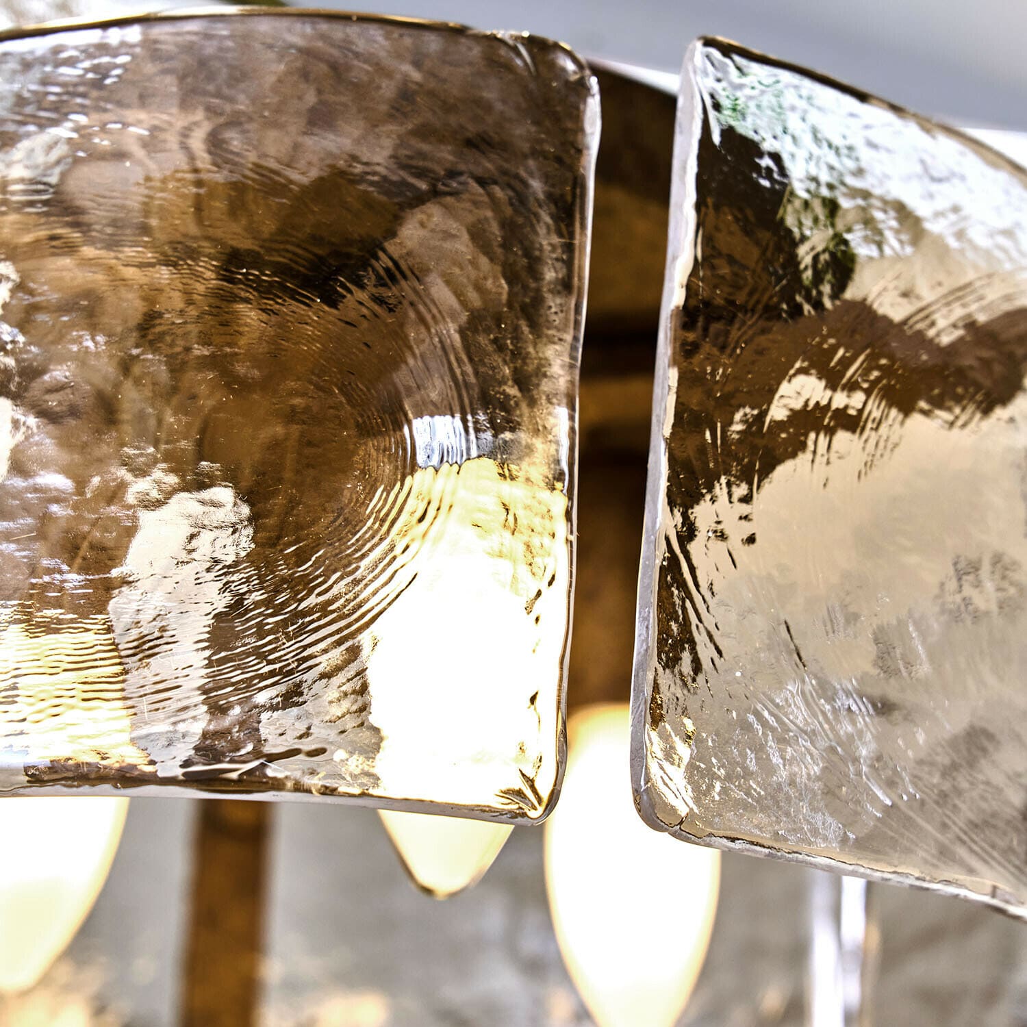 Glaslampenschirme mit welliger Struktur, transparent mit warmem Licht im Hintergrund