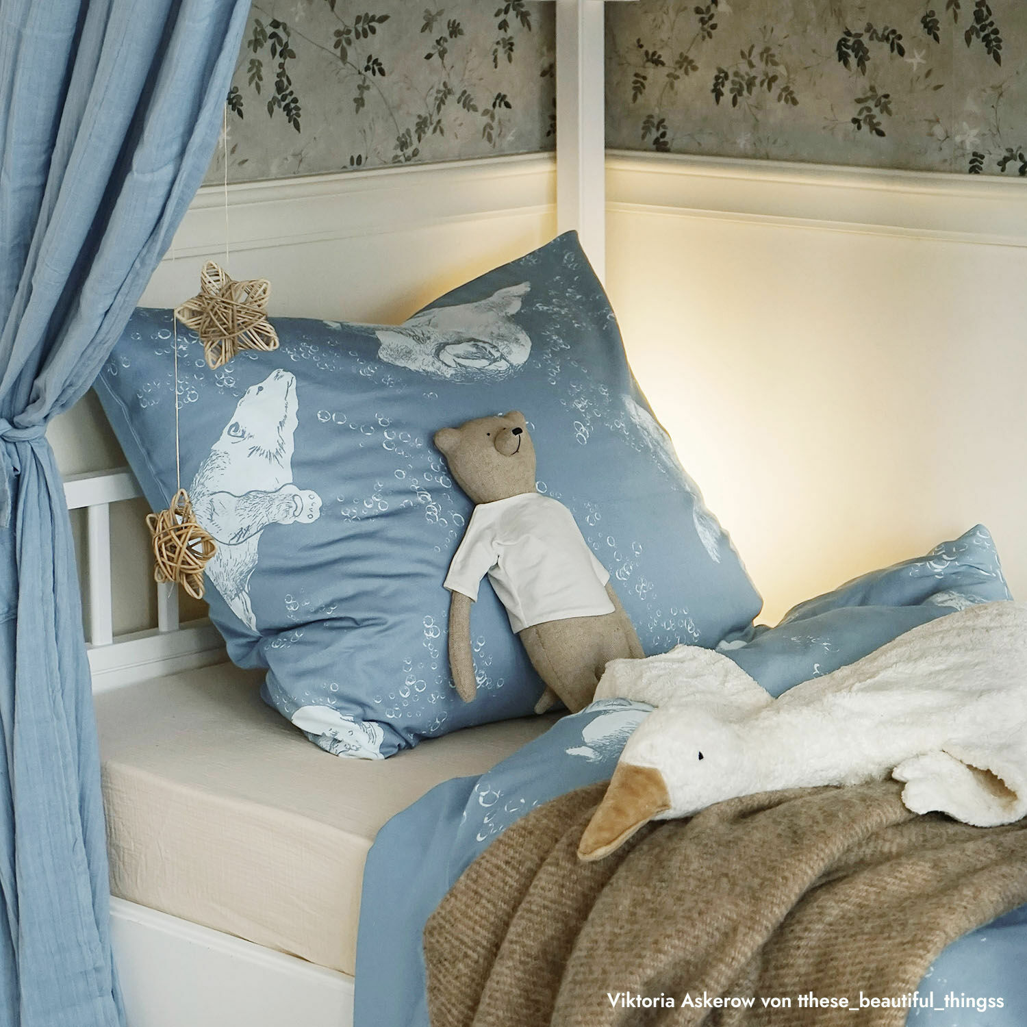 Blaue Baumwoll-Bettwäsche mit Eisbär-Motiv auf Kinderbett mit Kuscheltieren