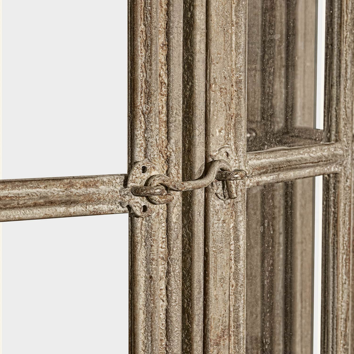Nahaufnahme eines Metallverschlusses an einem beige gealterten Spiegelrahmen im Vintage-Stil